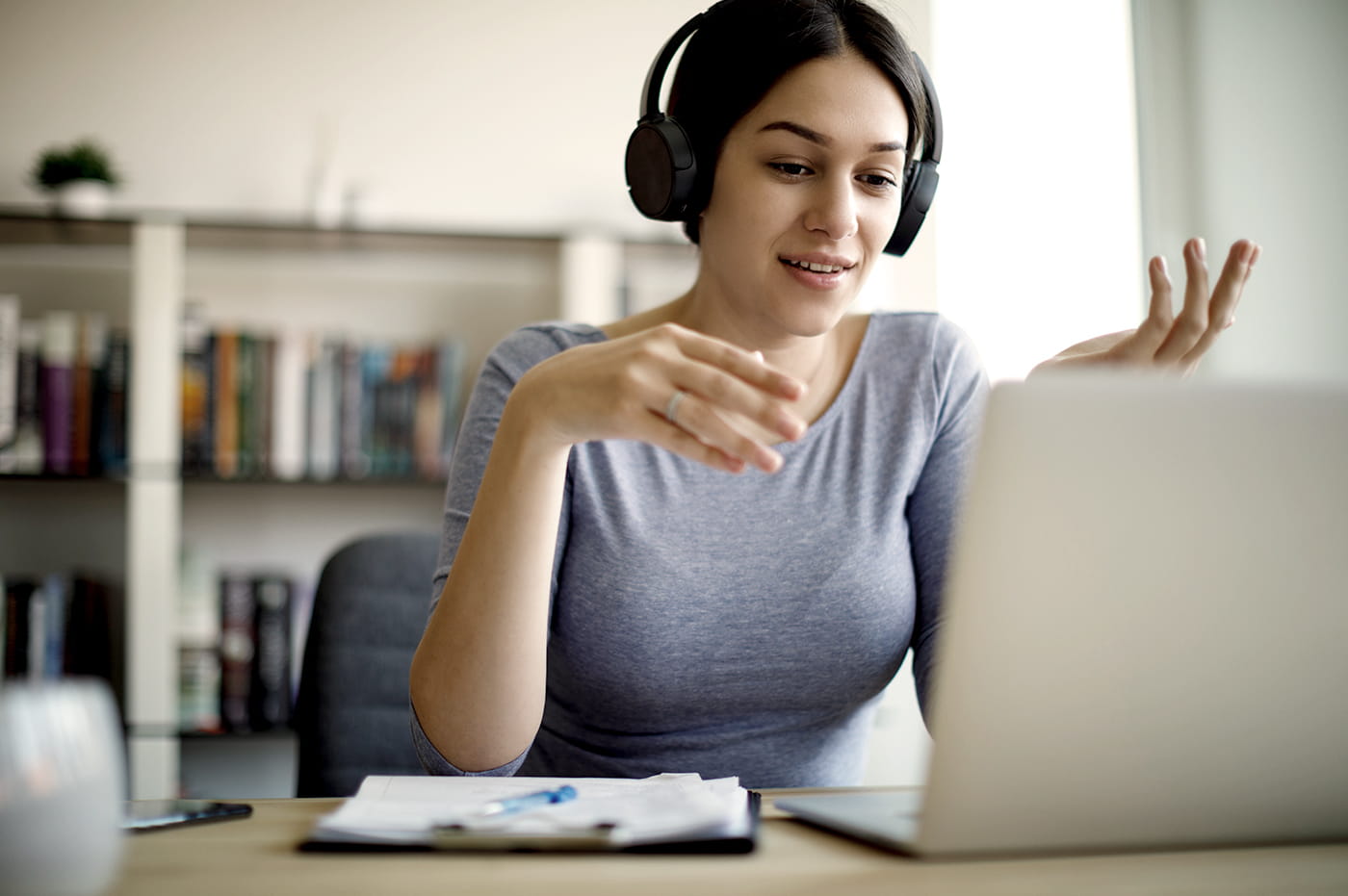 A woman working from home and talking on her headset.