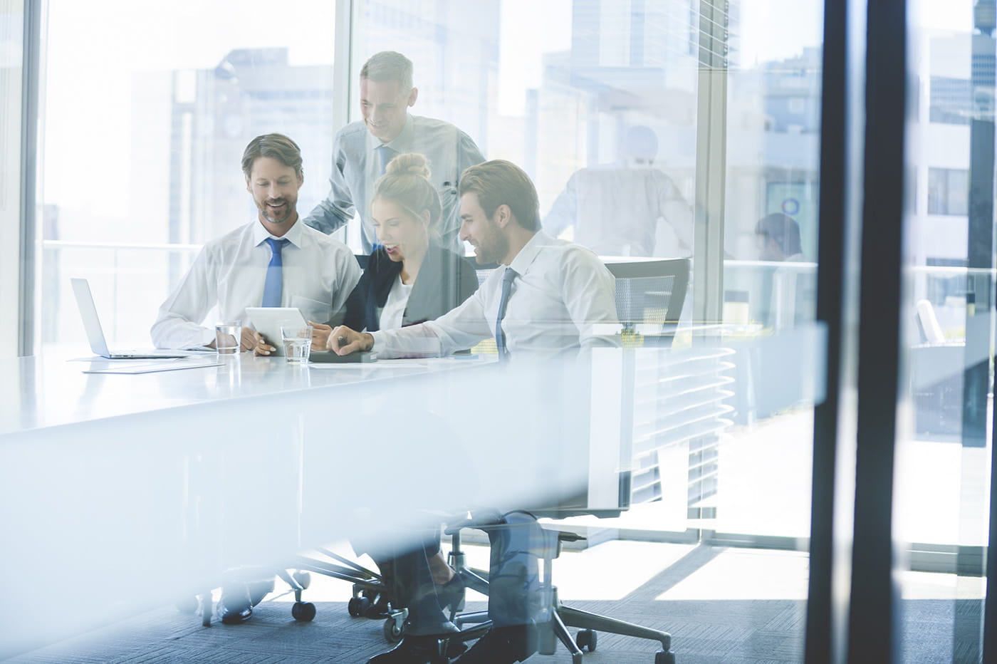 A group of people in a conference room smiling