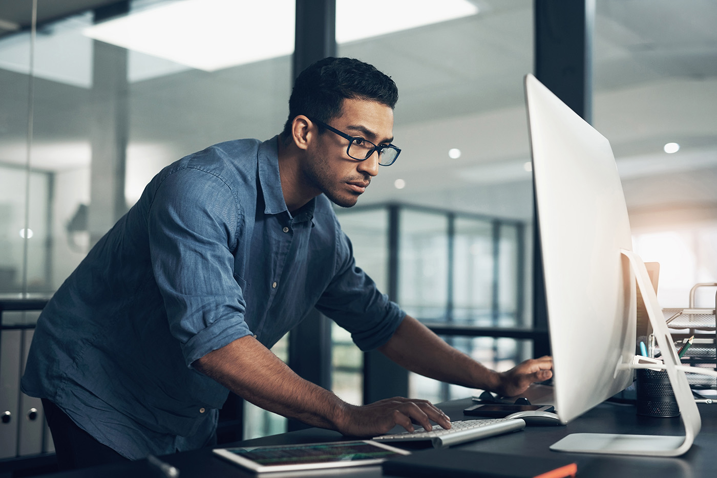 A man diligintely working on a desktop computer