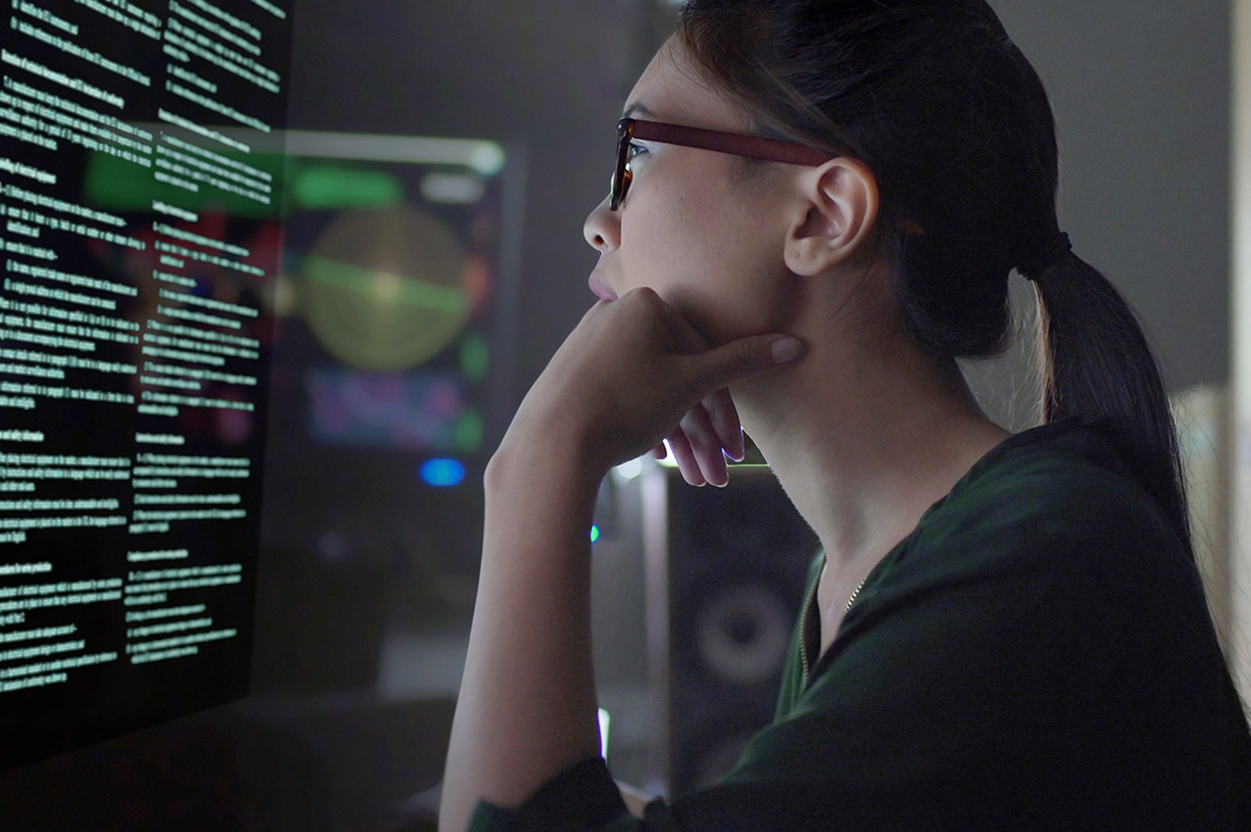 Woman working on coding on a large computer screen.