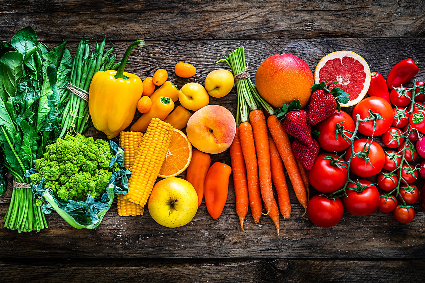 A rainbow created out of various fruits and vegetables.