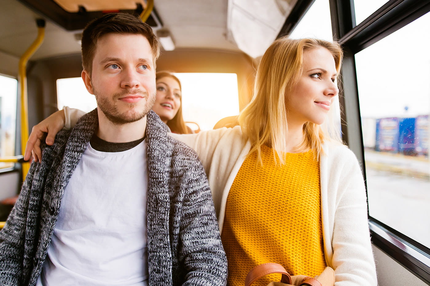 A young couple taking a trip on a bus together.