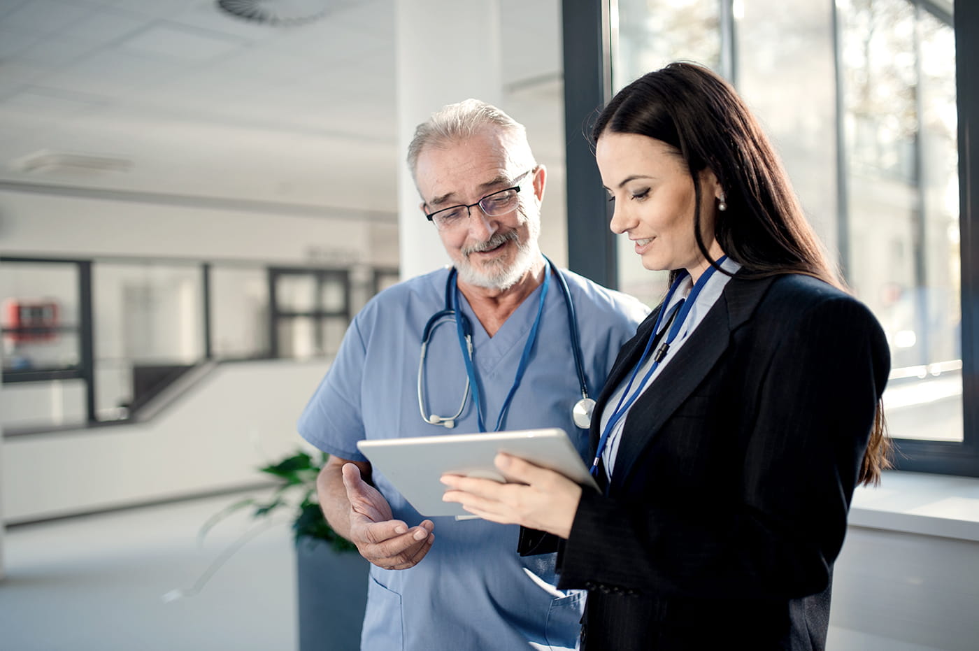 Two healthcare professionals looking at information on a tablet.