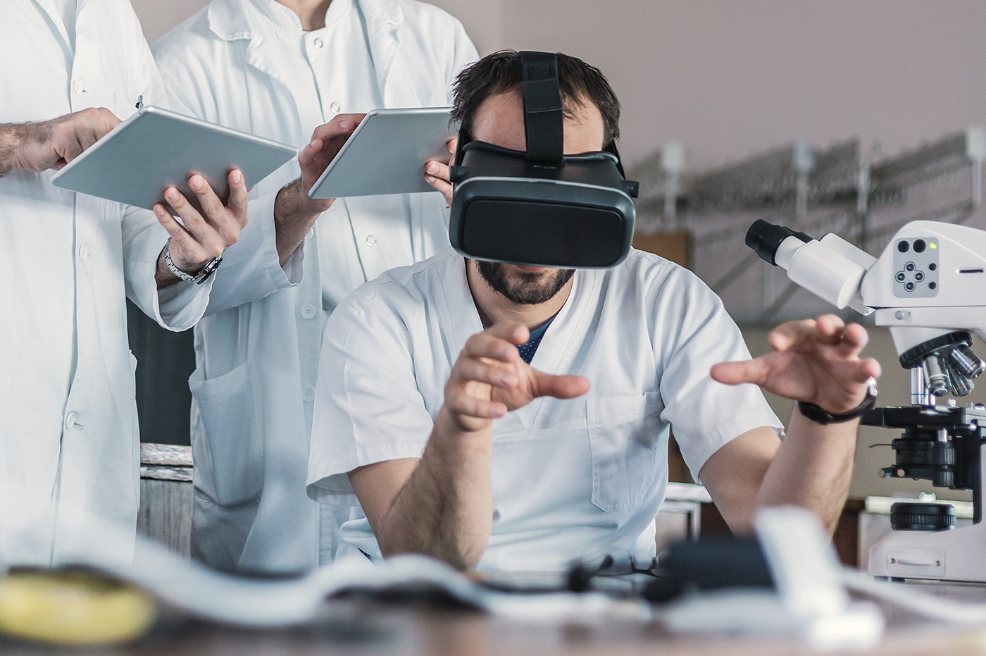 Man wearing a VR headset in a laboratory and a doctor studying it.