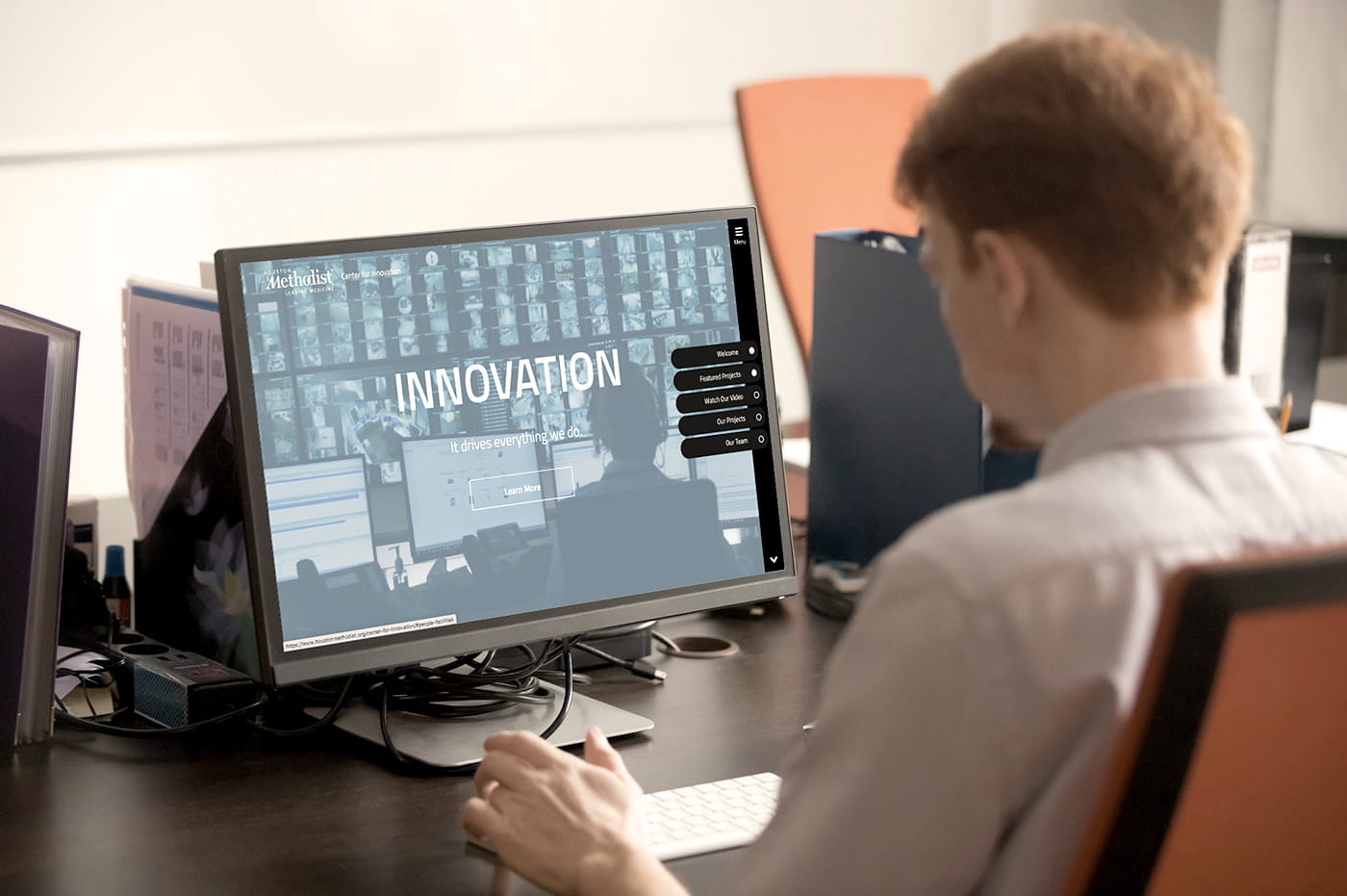 A man looking at a Houston Methodist website page on a desktop computer.