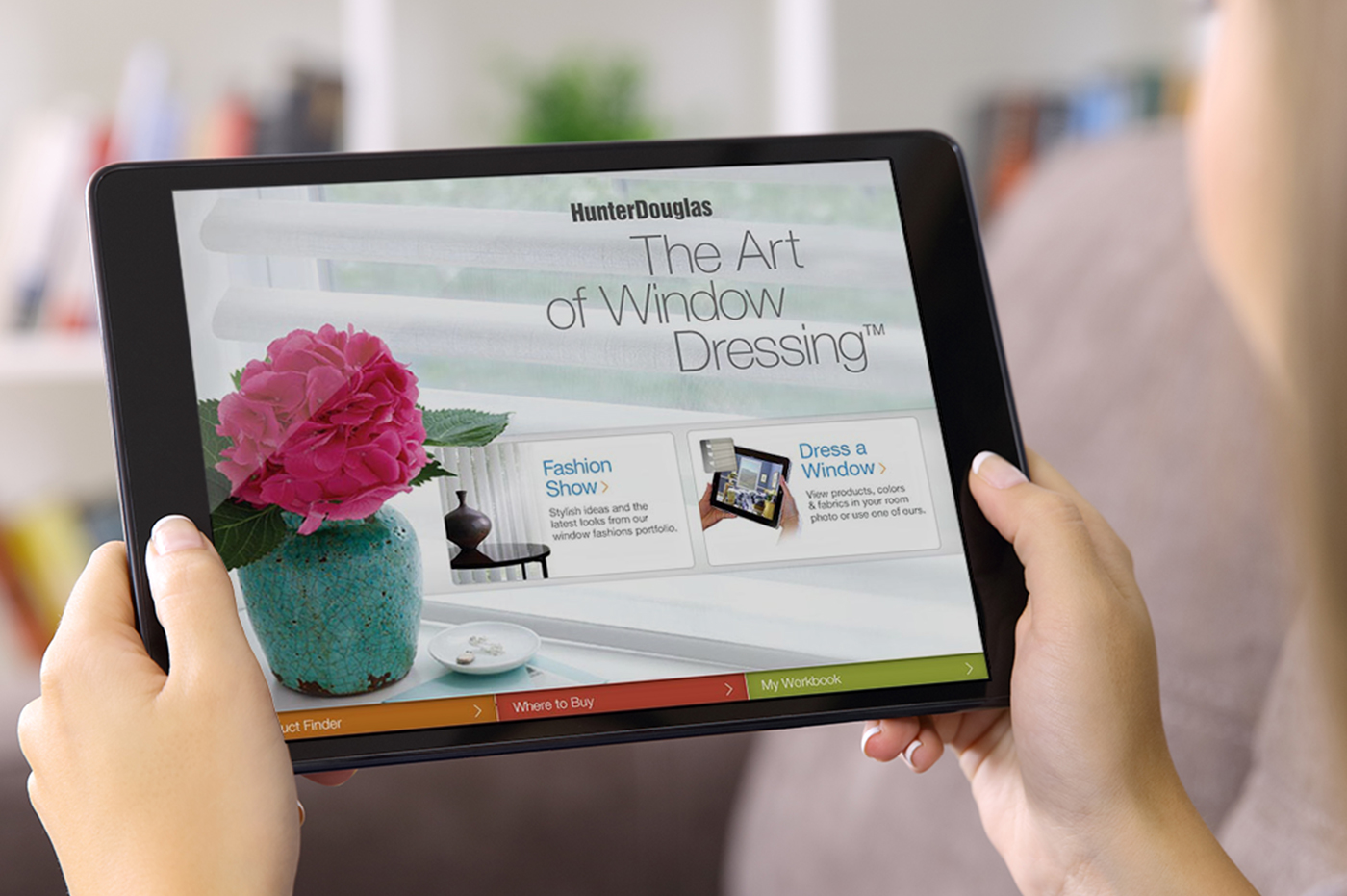 Woman holding tablet looking at Hunter Douglas Website