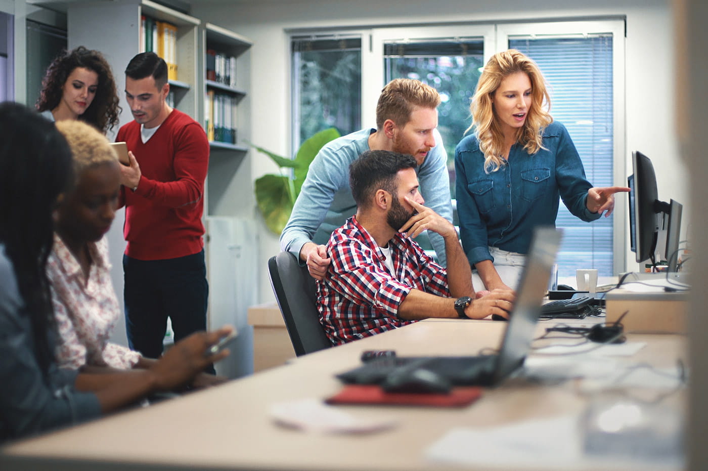 Groups of people in an office looking at different devices.