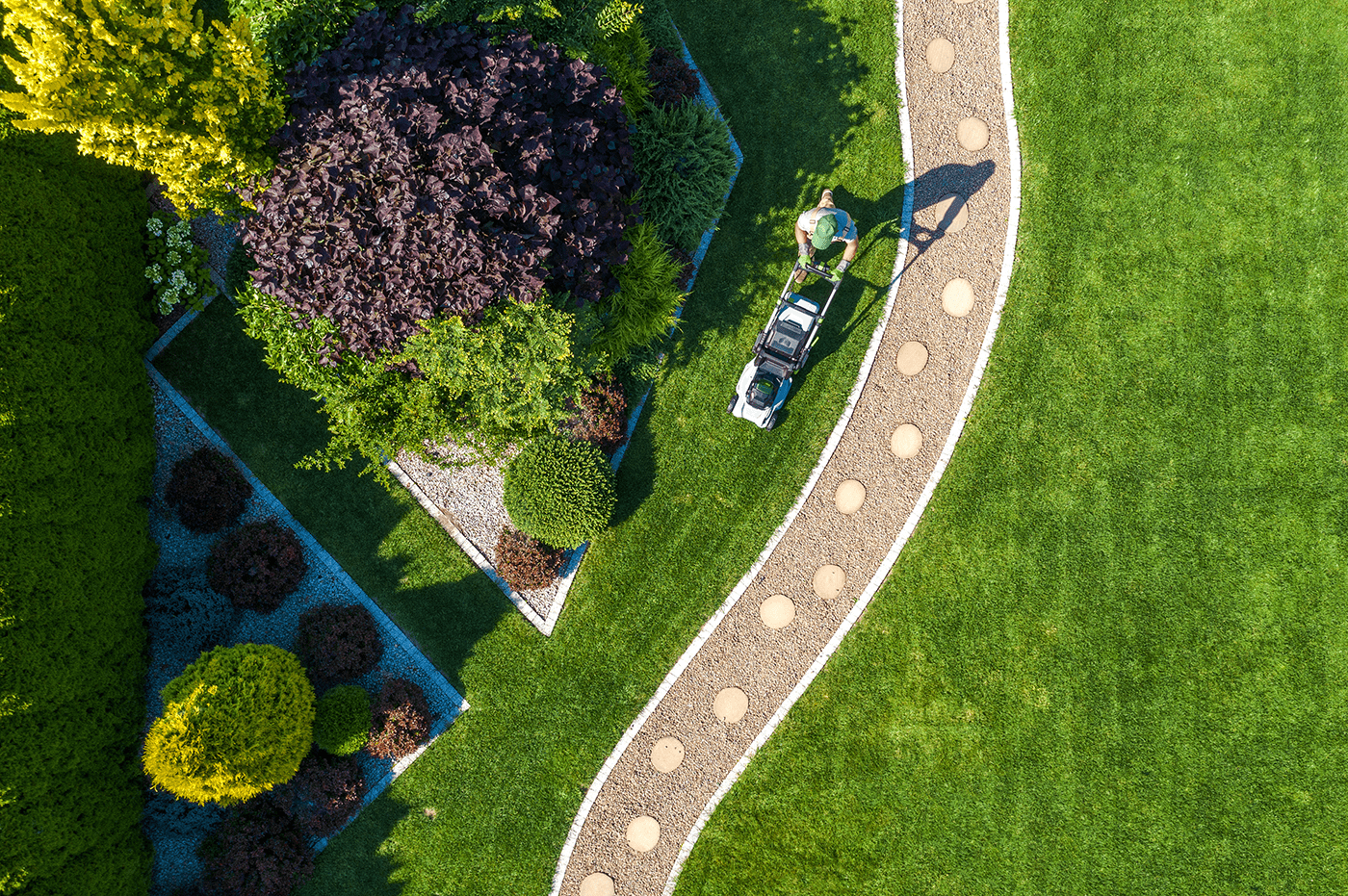 A man using a lawnmower in his backyard.