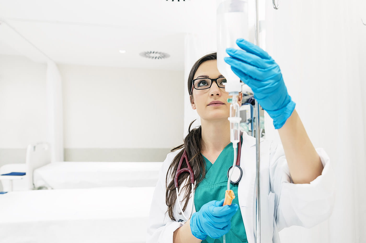 A healthcare worker preparing an IV drip with medicine.