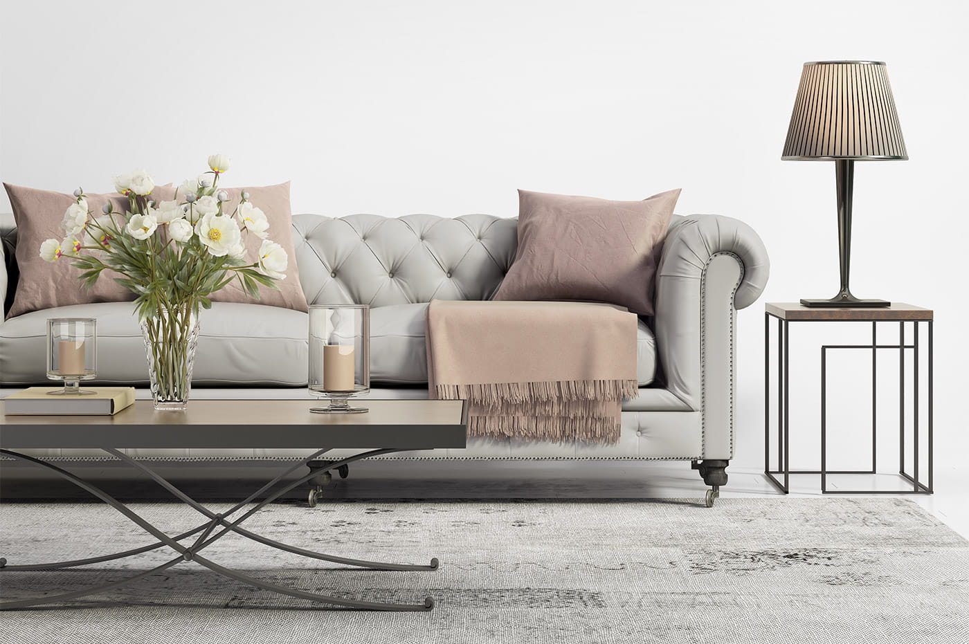 A grey couch with throw pillows and a blanket in a living room.