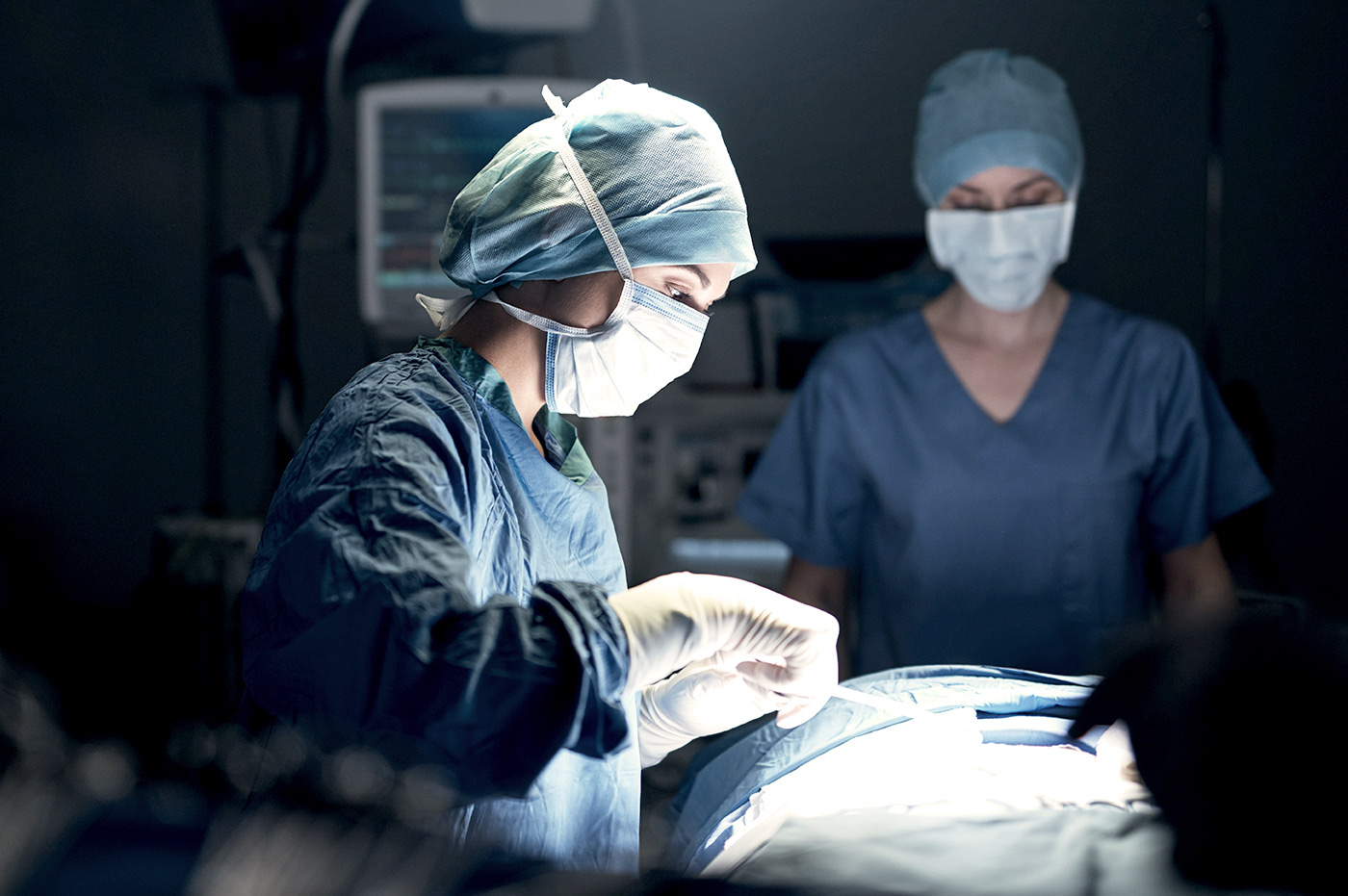 A surgeon performing an operation on a patient with a nurse.