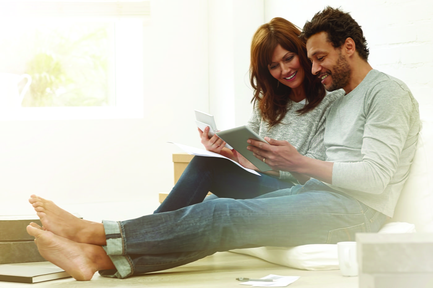 A couple at home reviewing their insurance on a tablet device.