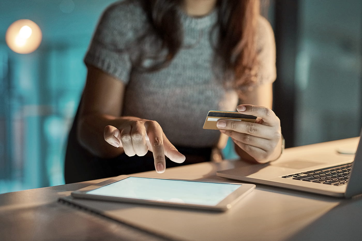 Woman filling out credit card information on a tablet device. 