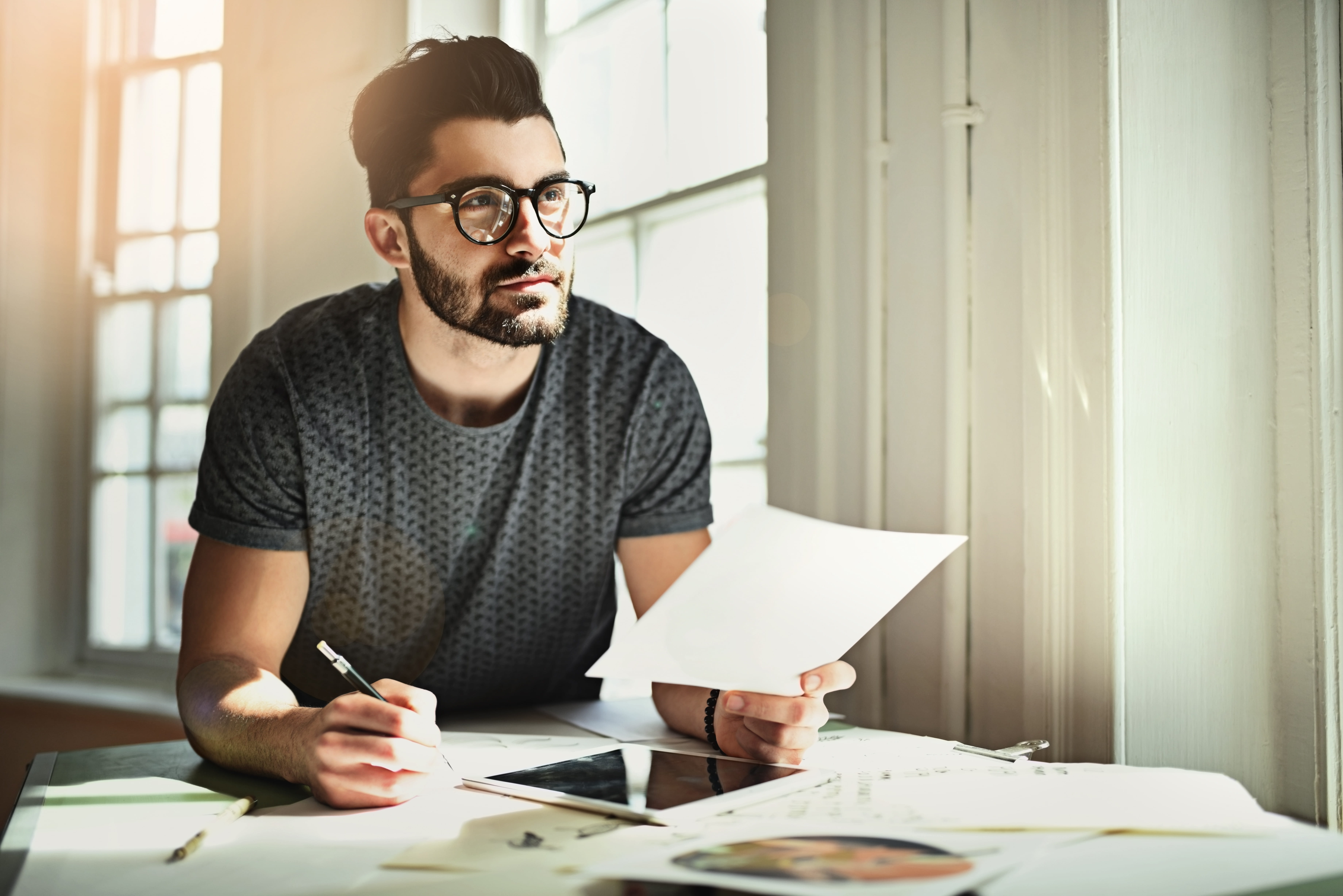 A pensive hunk working on documents. 