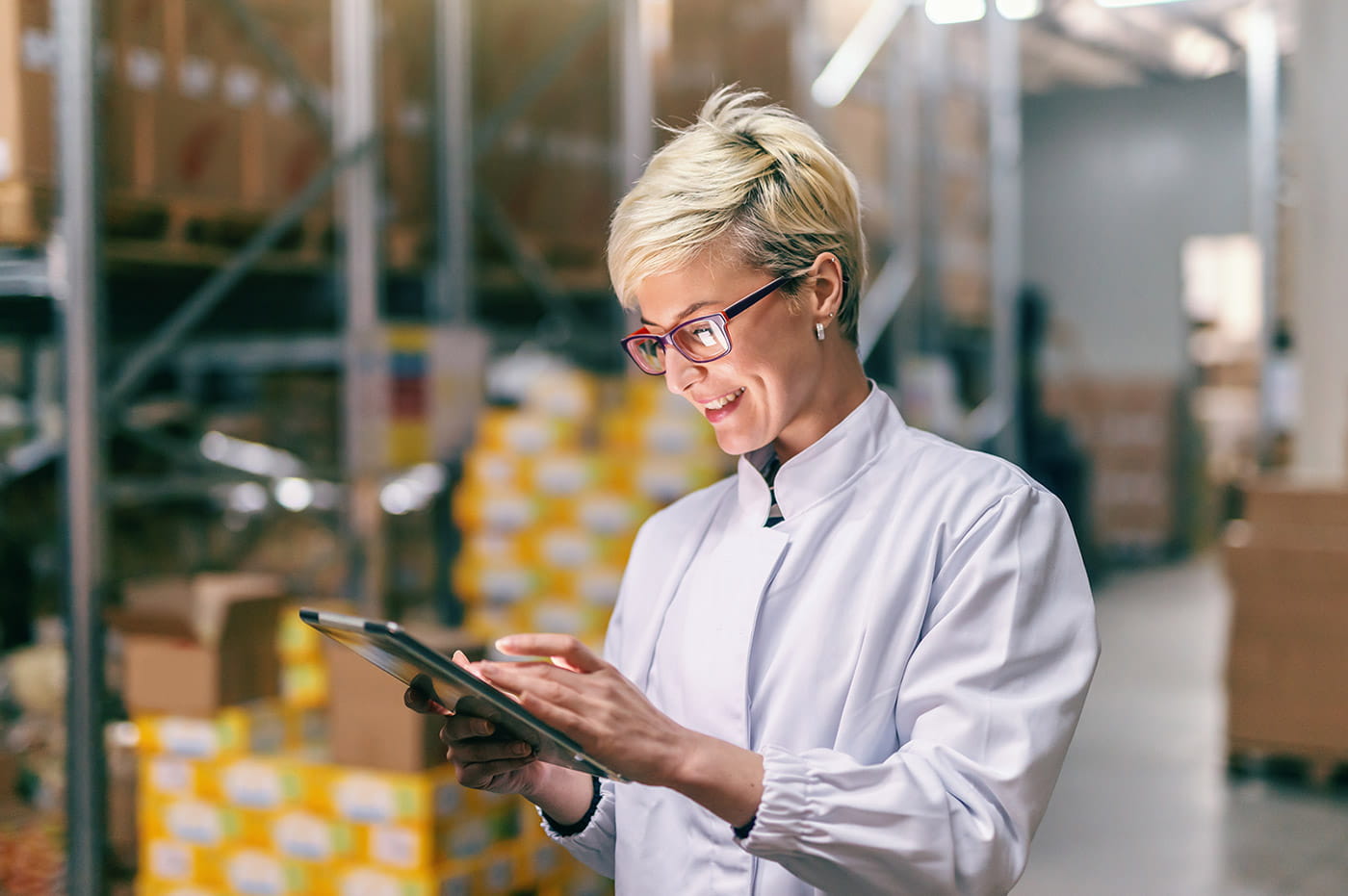 Female business woman working on an iPad in a warehouse.