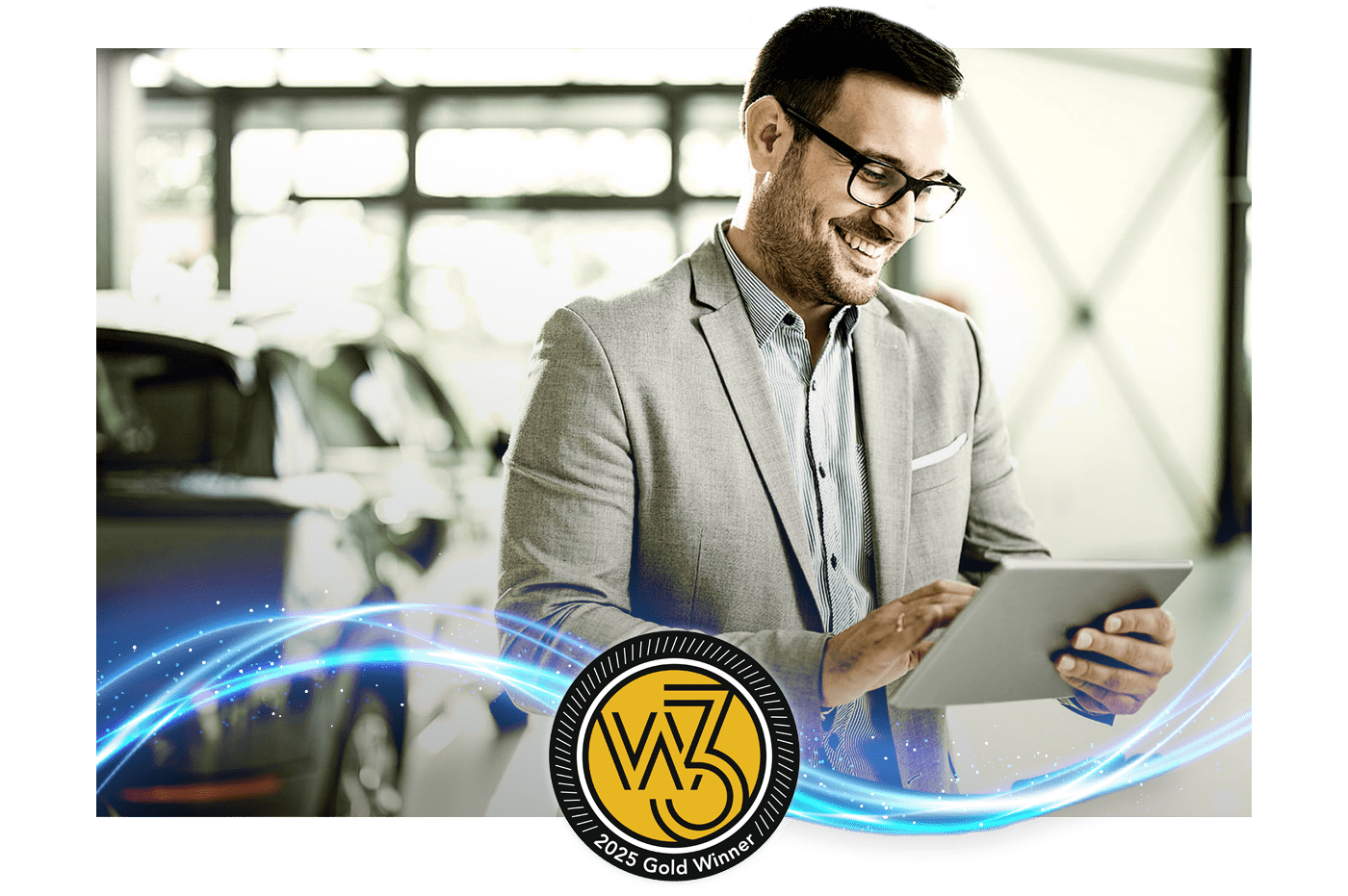 A man working on an iPad in a car showroom. Gold W3 award badge