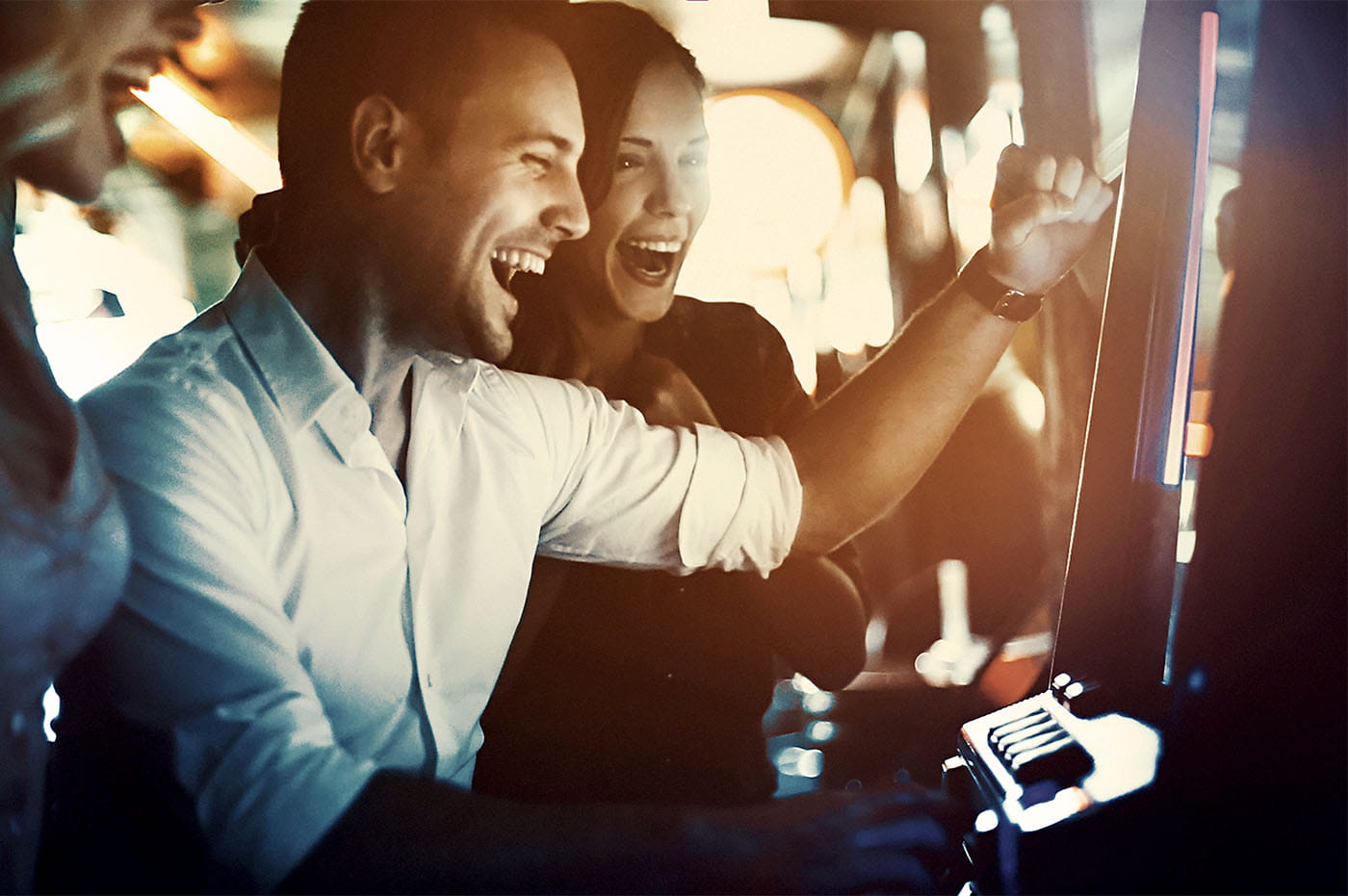 A group of people cheering after winning on a slot machine.