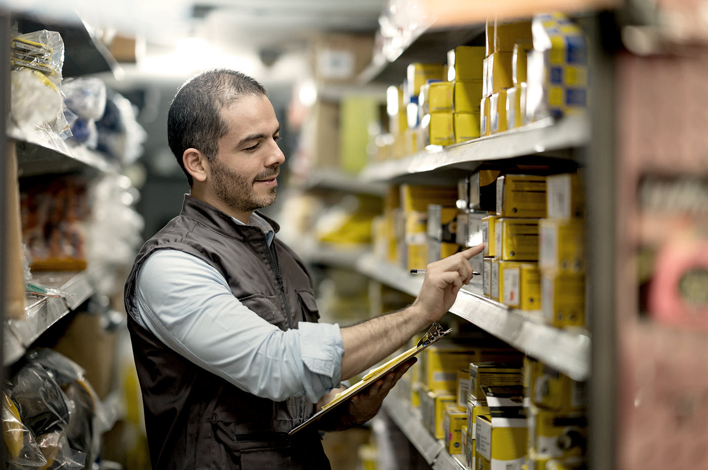 A man taking inventory of stock in a warehouse.