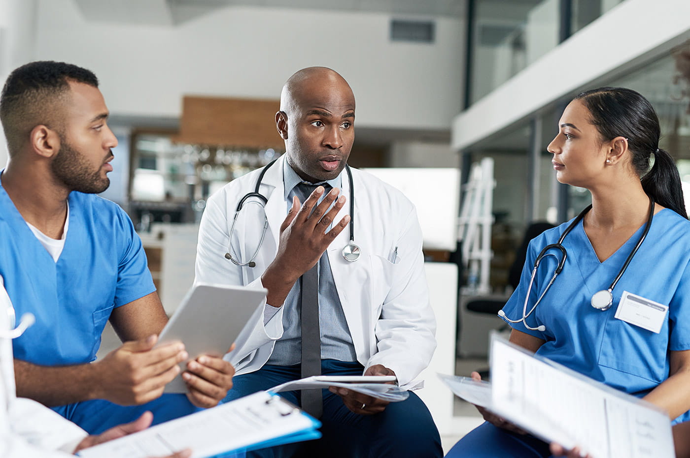 Three healthcare workers looking at charts and discussing.