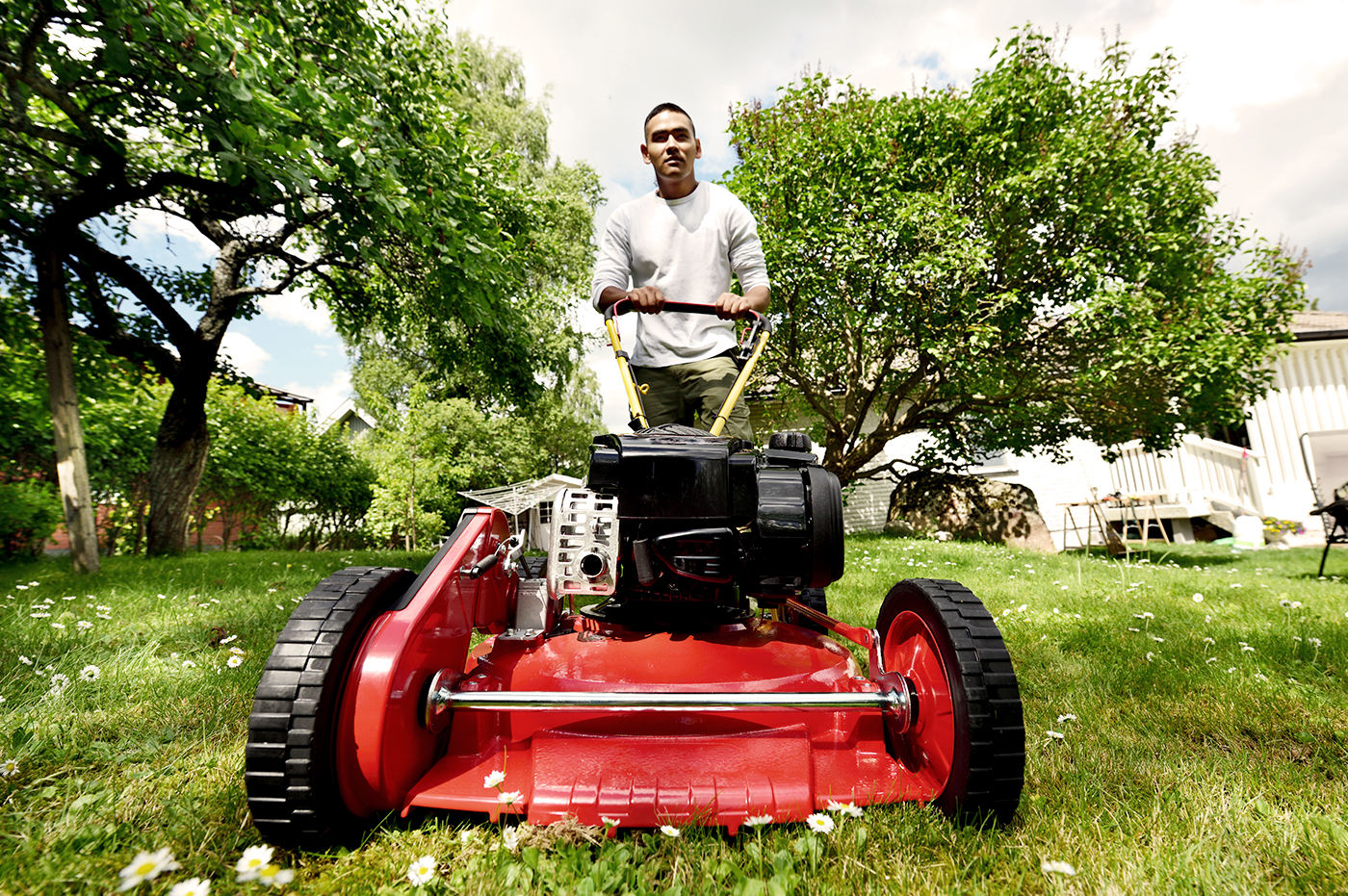 Close-up of a person using a push lawn mower.