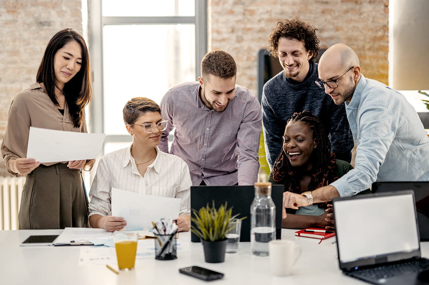 Coworkers in a meeting looking a papers and at a tablet device