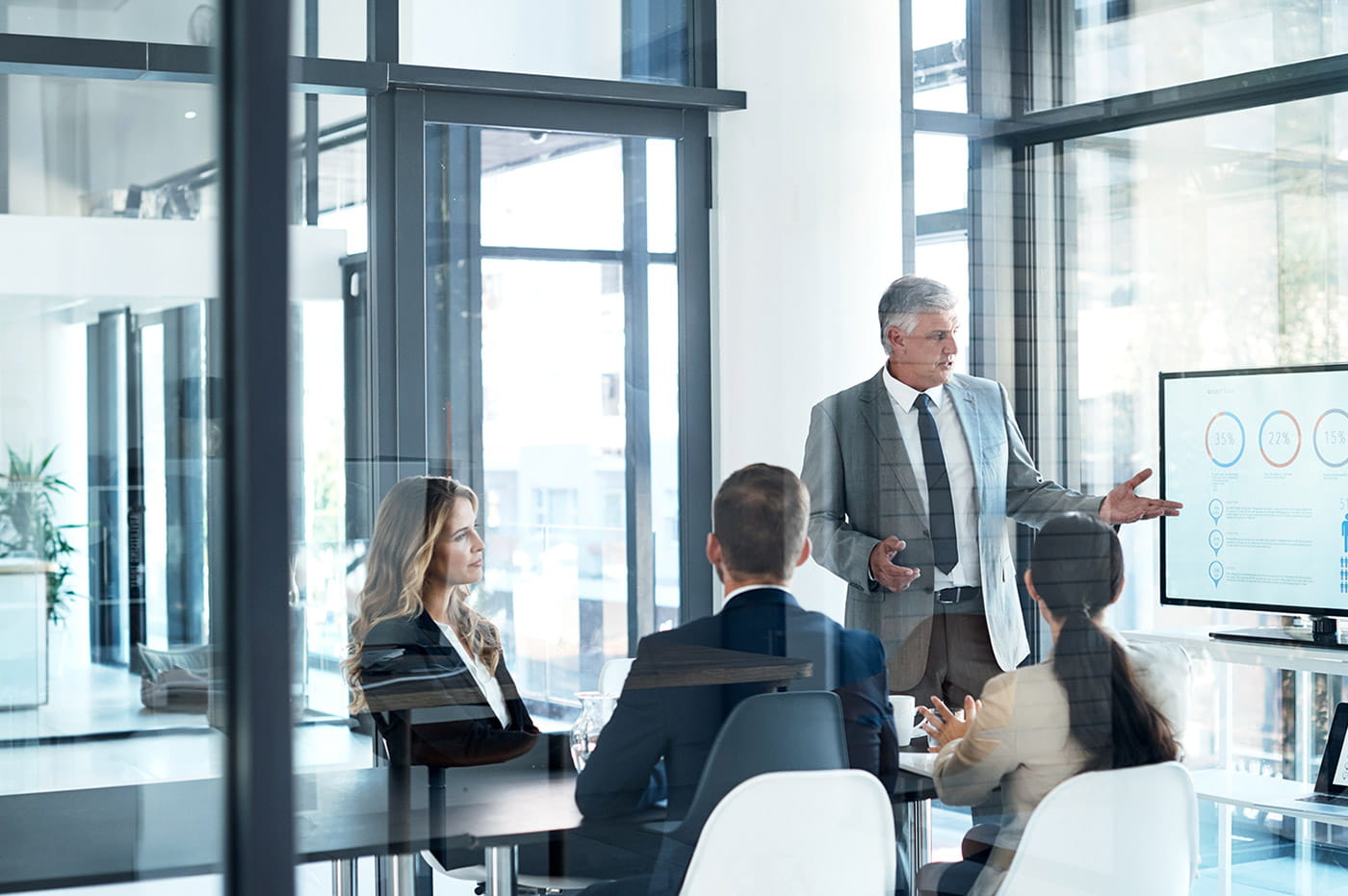 A group of professionals in a conference room looking at data on a large screen.