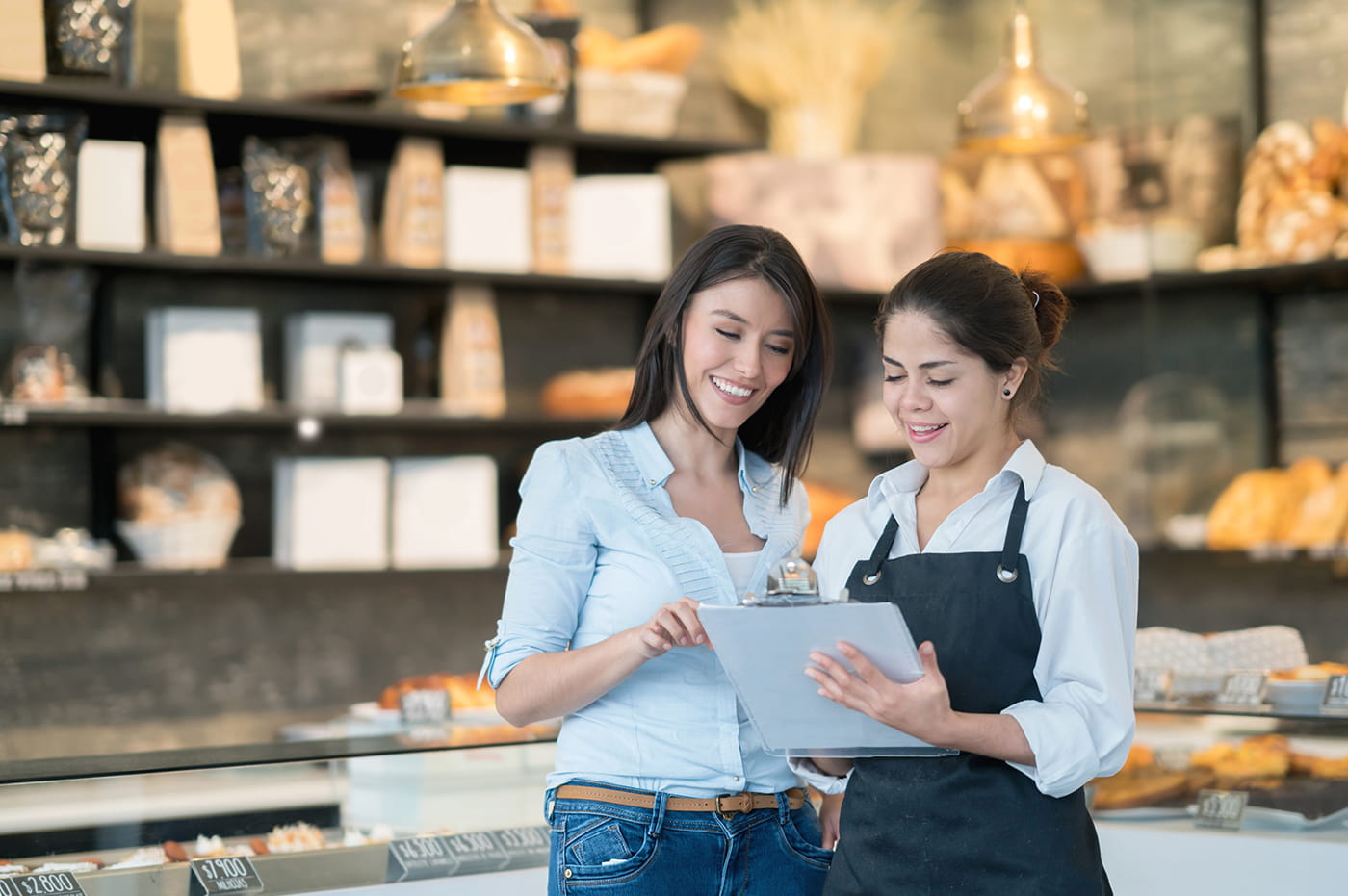 Two people looking at information together in a bakery.