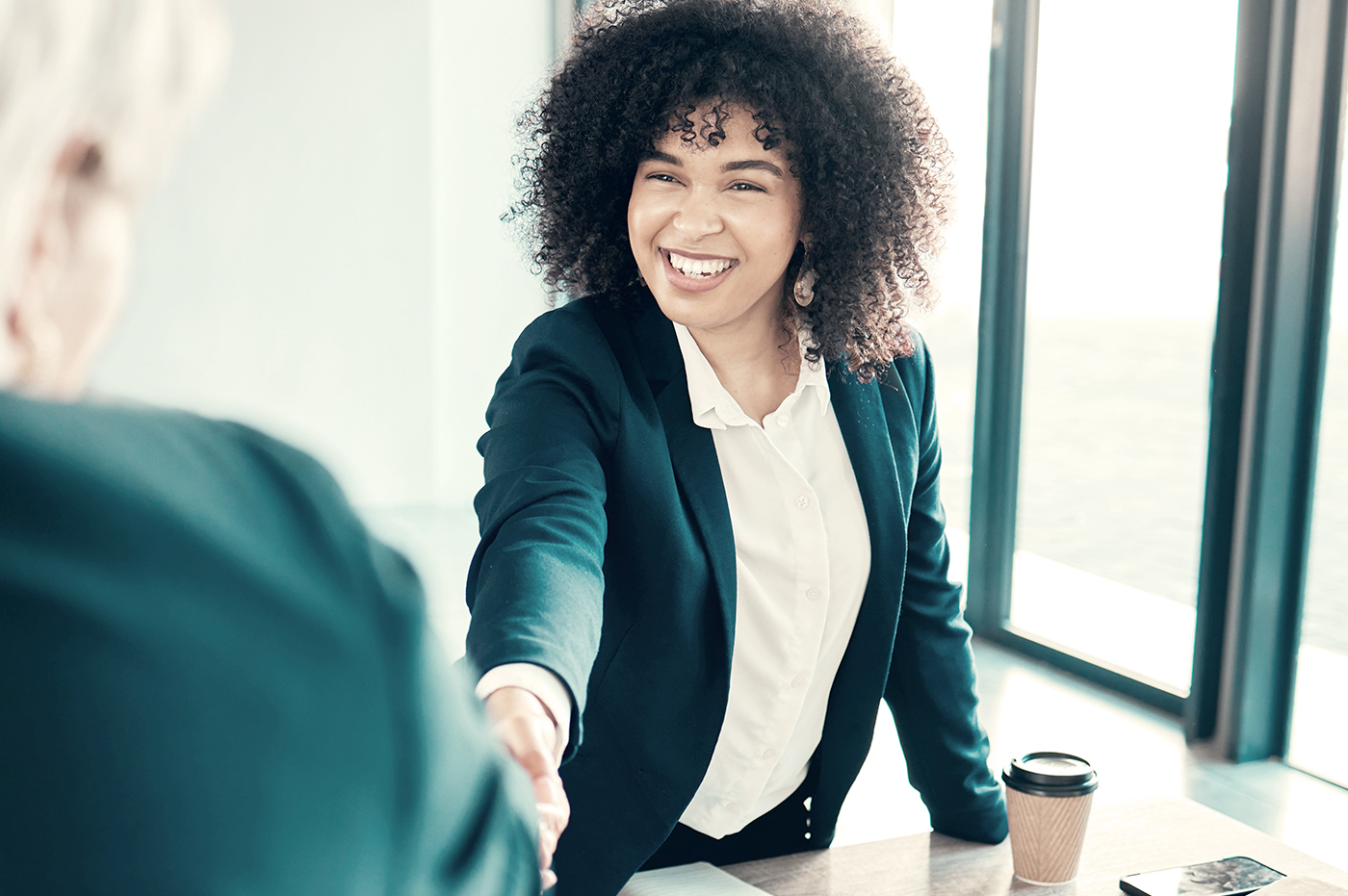 A woman shaking hands with another person.