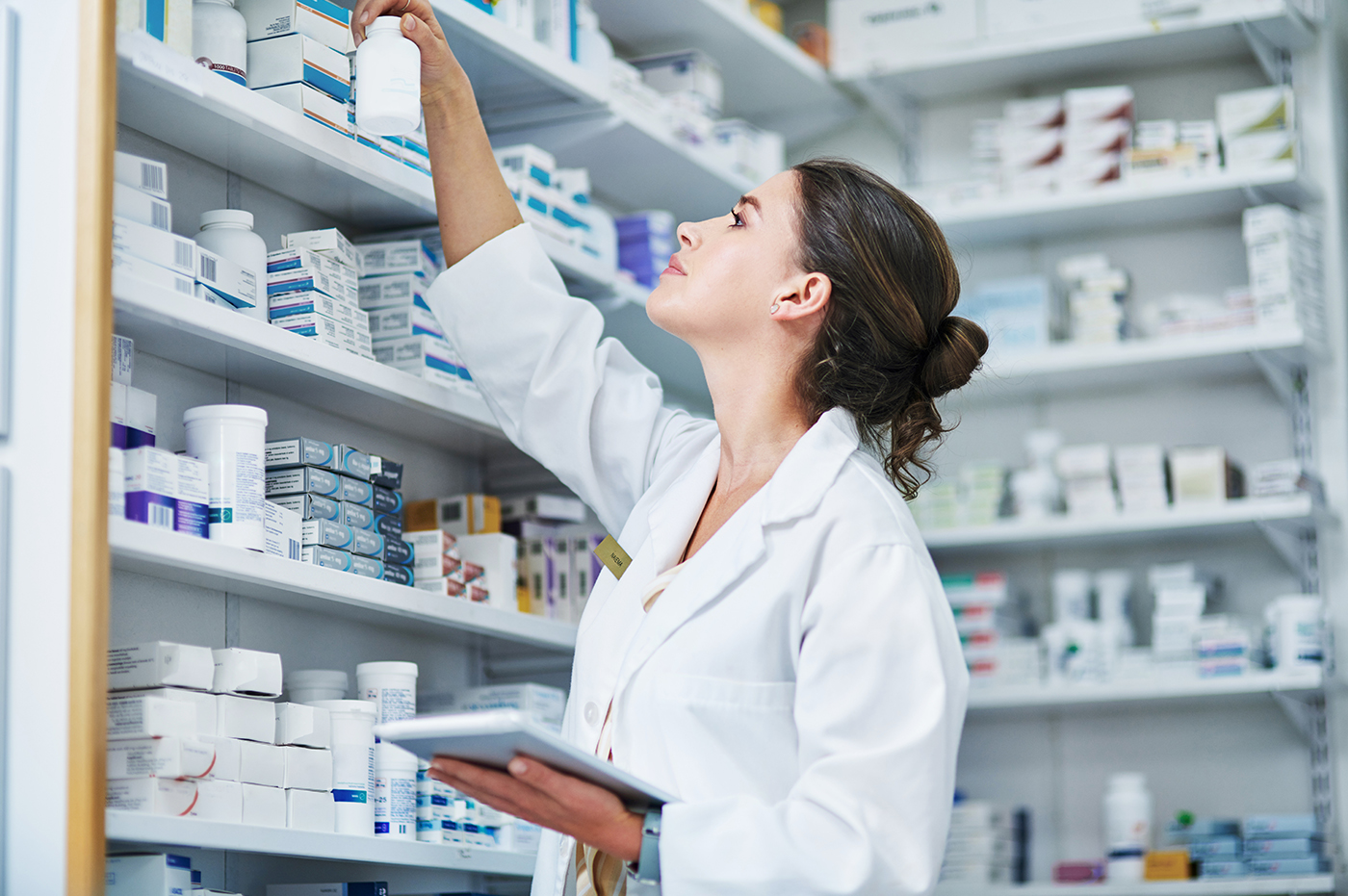 A Healthcare worker pulling a prescription off a shelf 