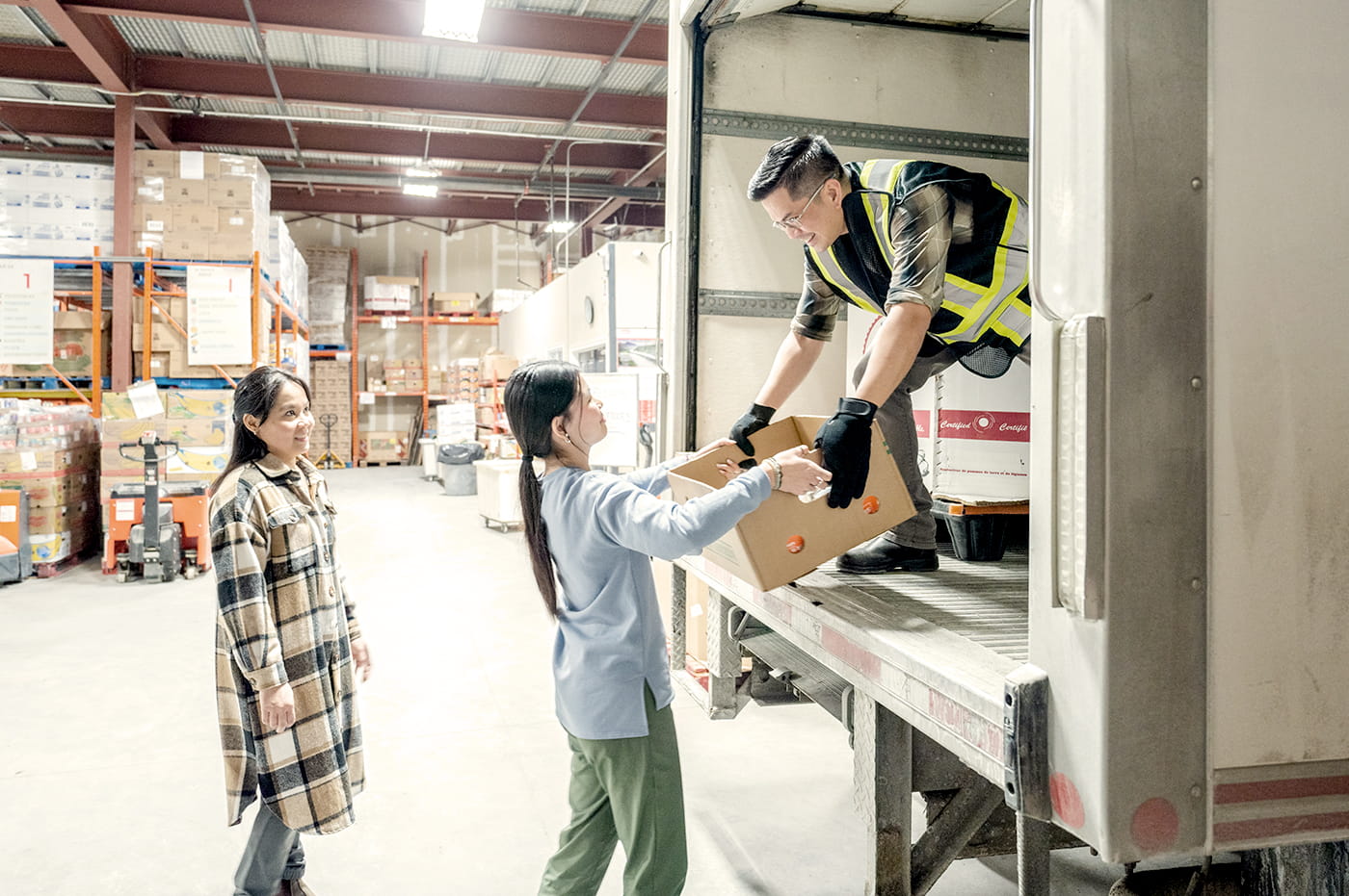 A delivery person delivering boxes to people in a warehouse.