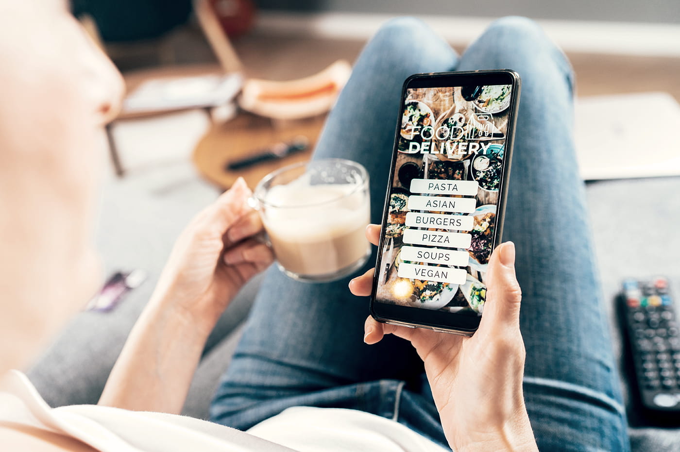 A woman looking at a food delivery app on a smart phone.