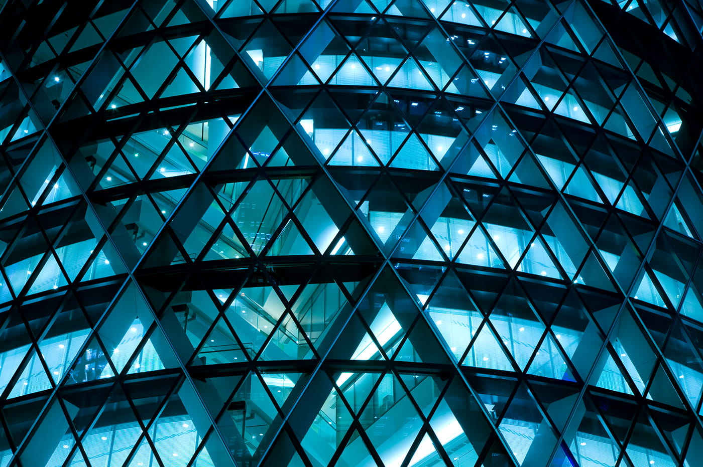 An office building through diamond-shaped windows and beams.