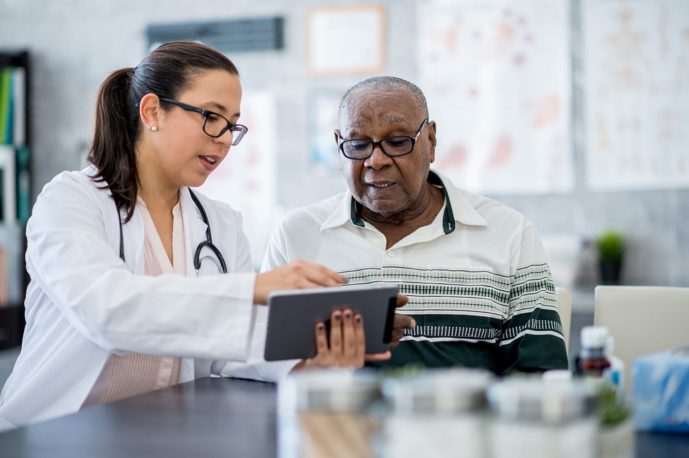 A female healthcare worker reviewing information on a tablet with her patient.