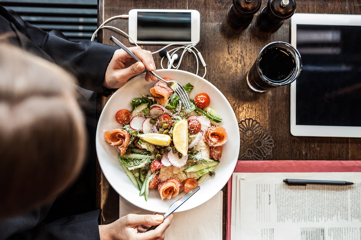 Someone eating a salad with lemon.