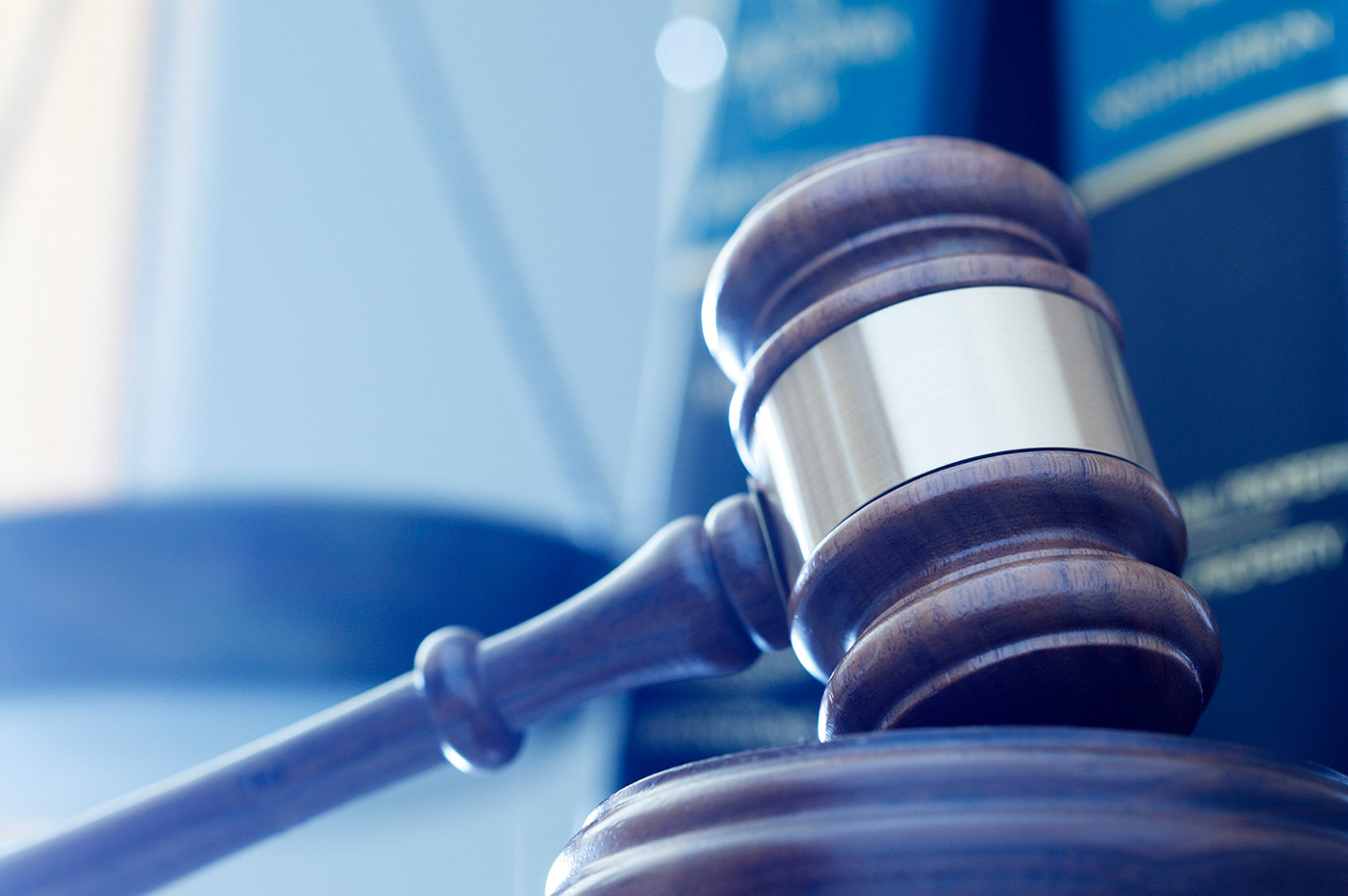 A gavel resting in front of some law books.