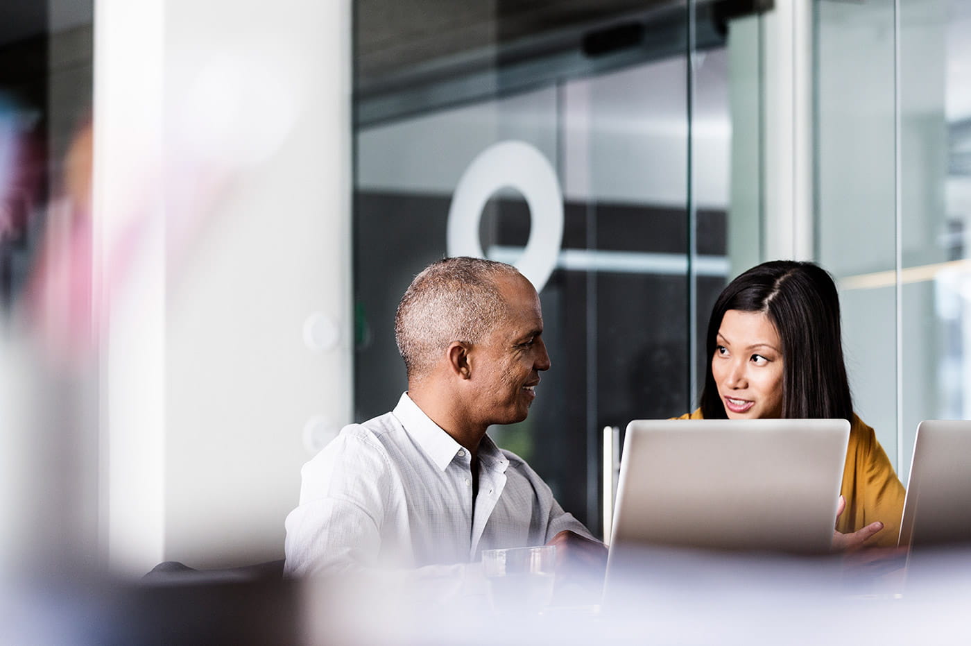 Two coworkers discussing something and looking at a computer.