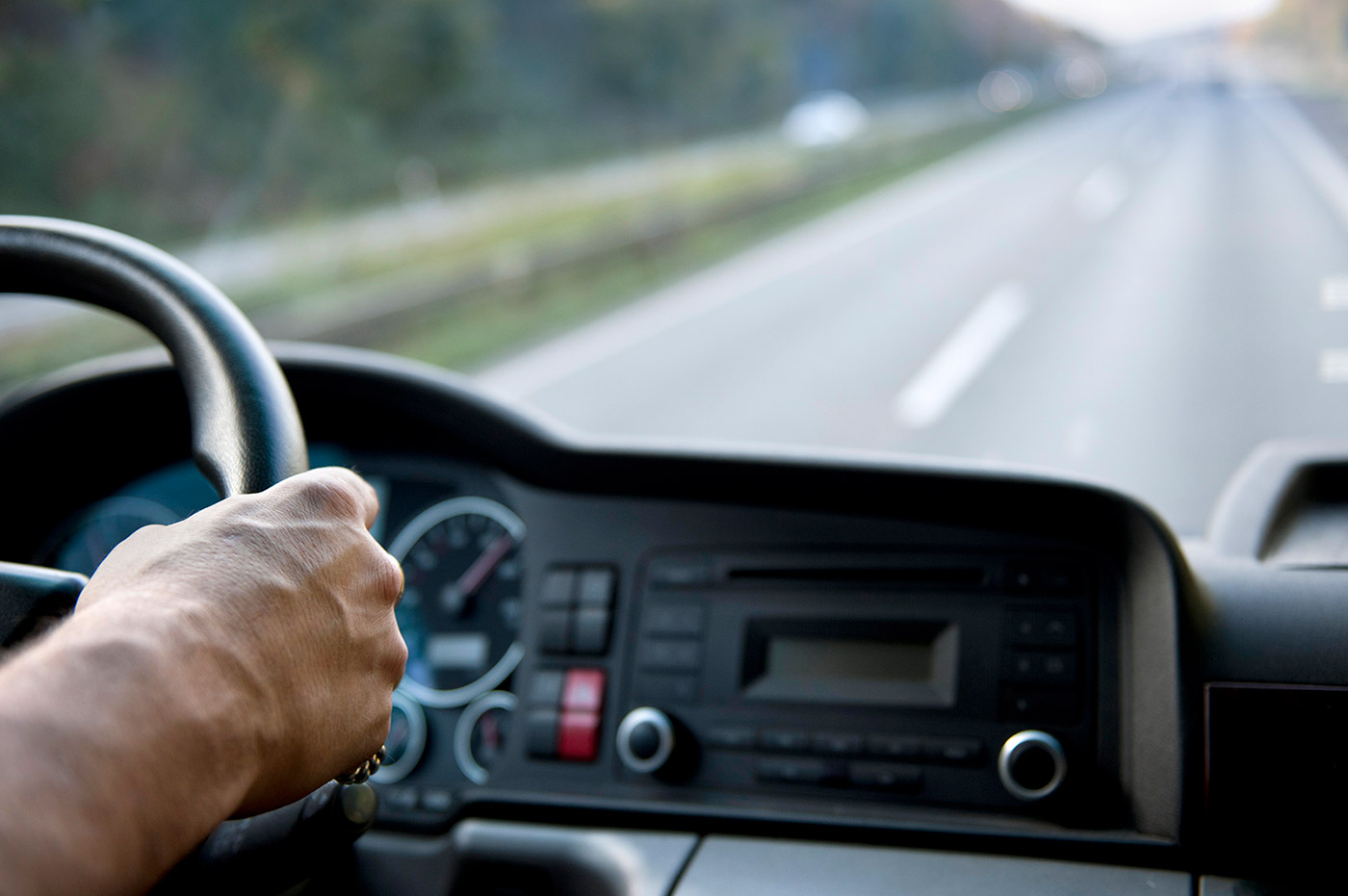 A pair of hands holding a steering wheel.