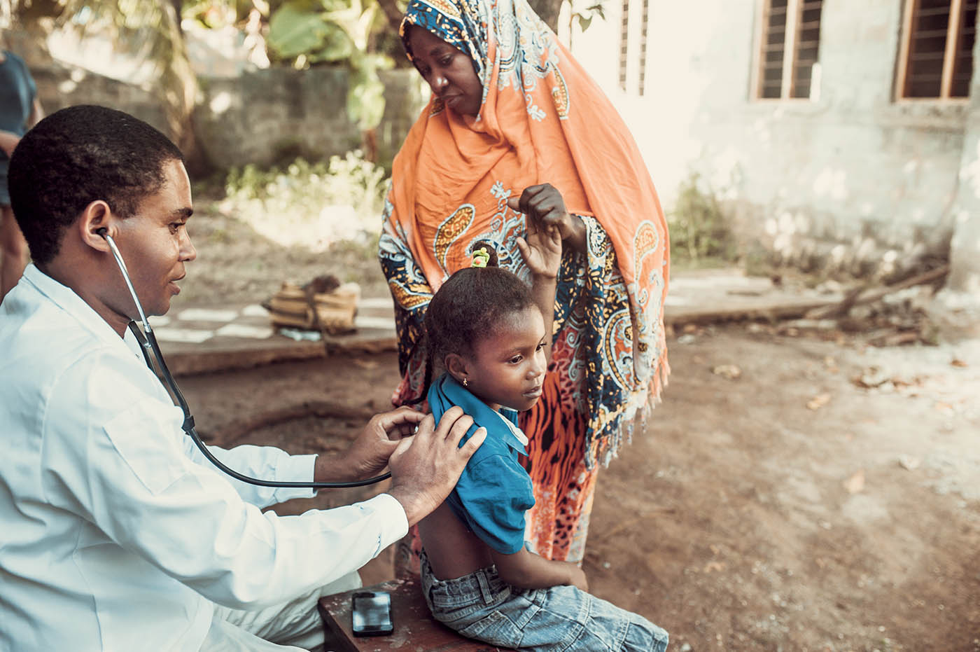 A doctor using a stethoscope to listen to a child's heartbeat.