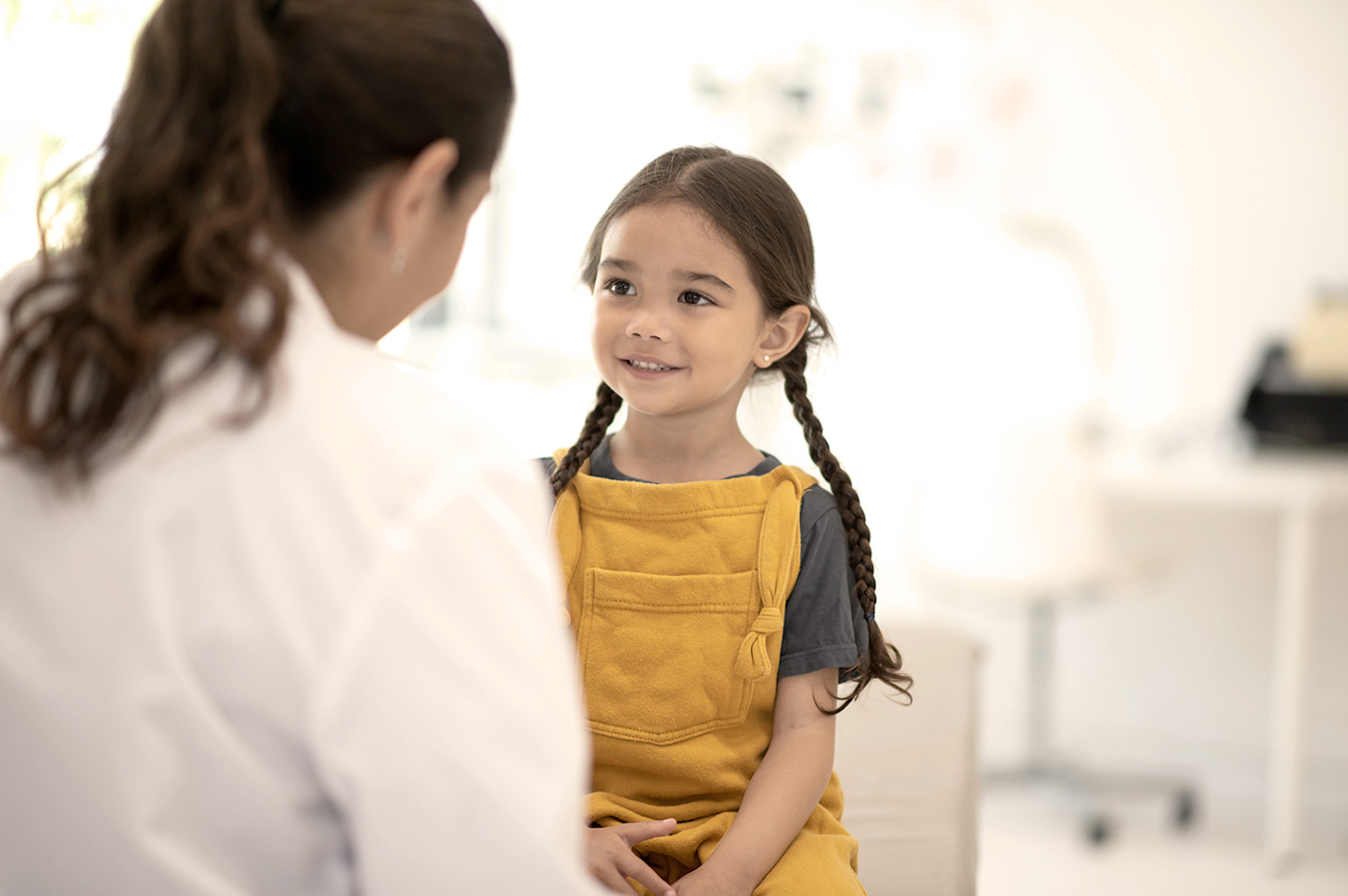 A little girl with her doctor in a doctor's office.