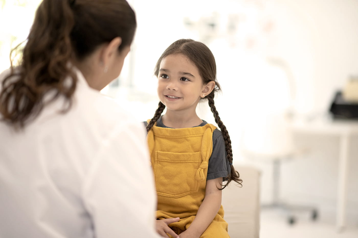 A little girl with her doctor in a doctor's office.