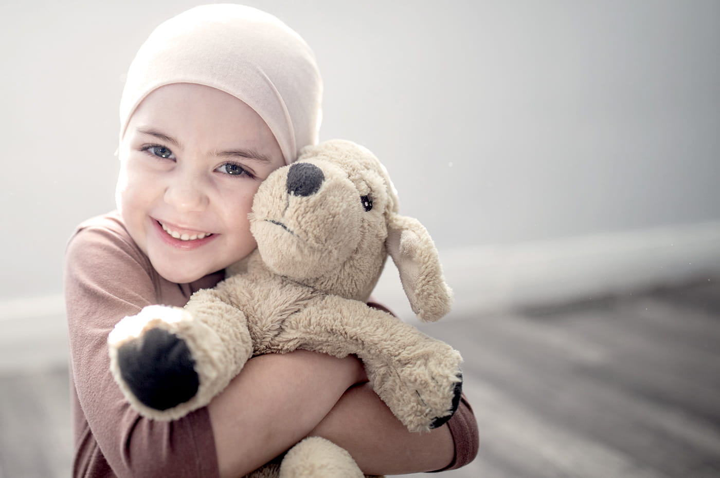 A little girl hugging her stuffed dog.