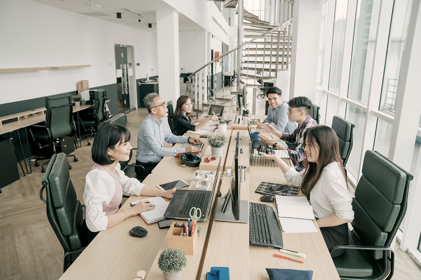 A large group of colleagues sitting in an open workspace.