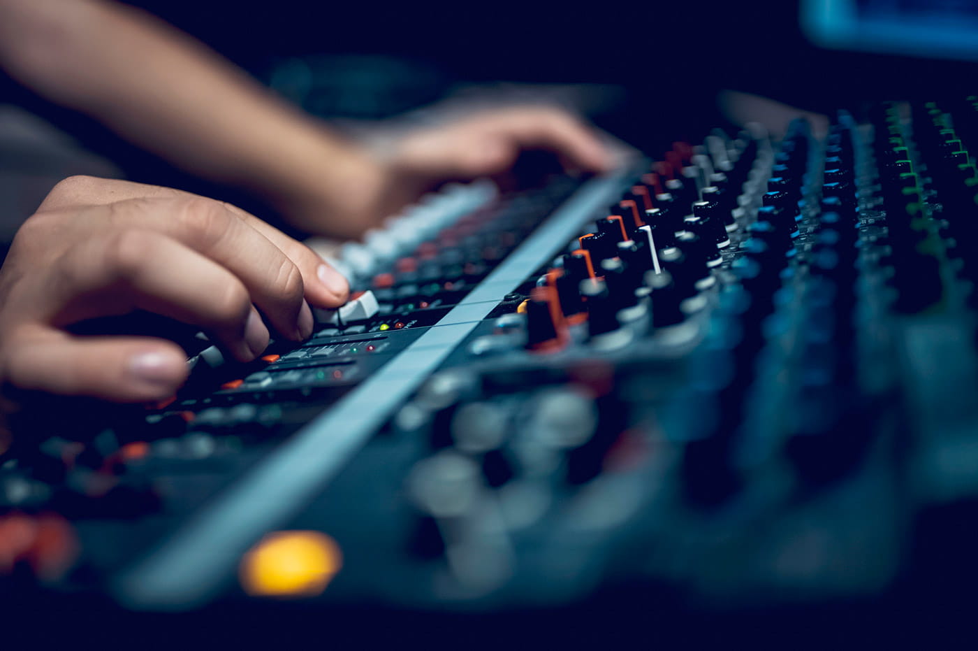 Pair of hands working on a sound equipment switchboard.