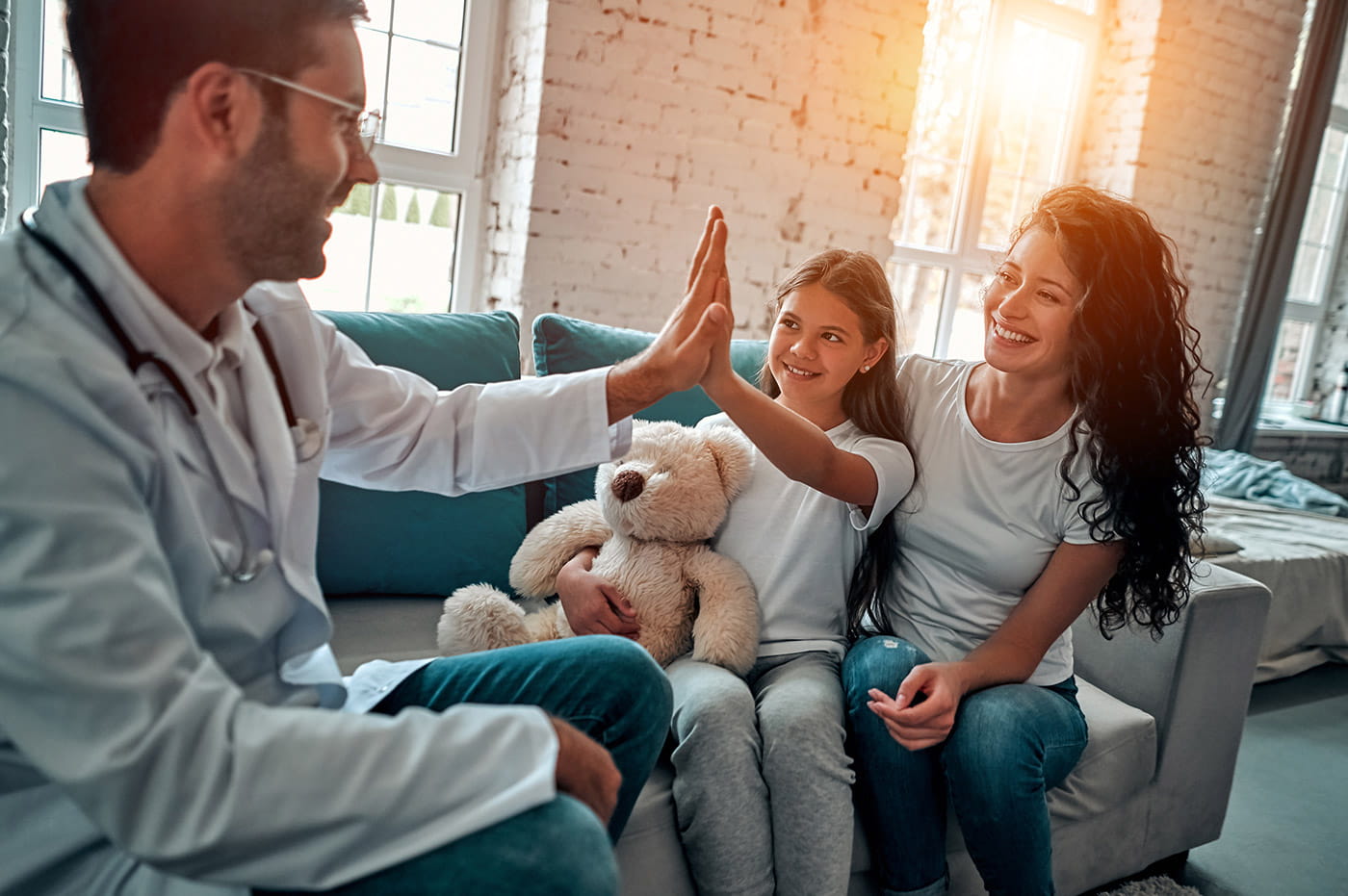 A doctor giving a young patient a high-five.