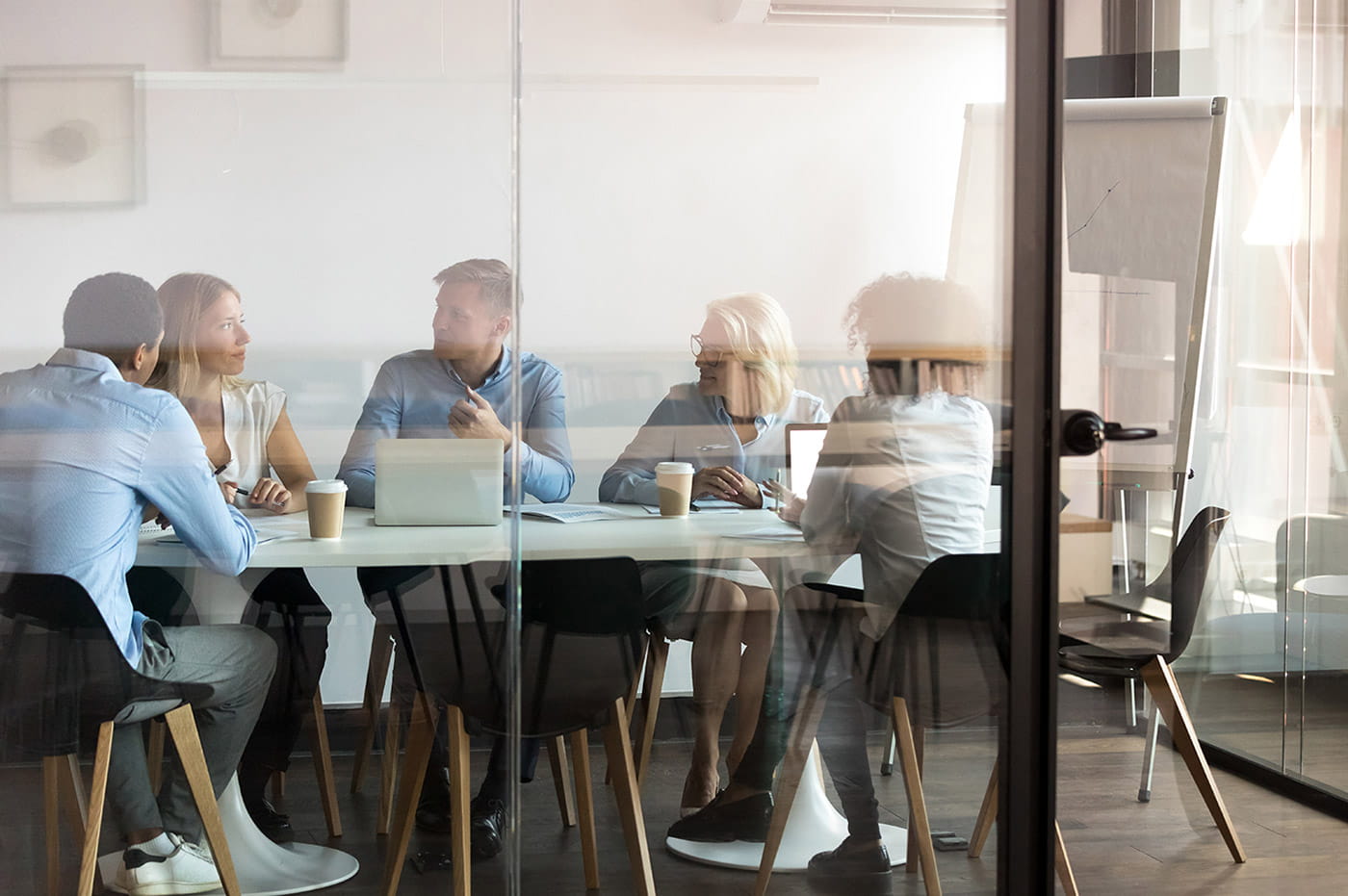 A group of coworkers talking in a conference room.