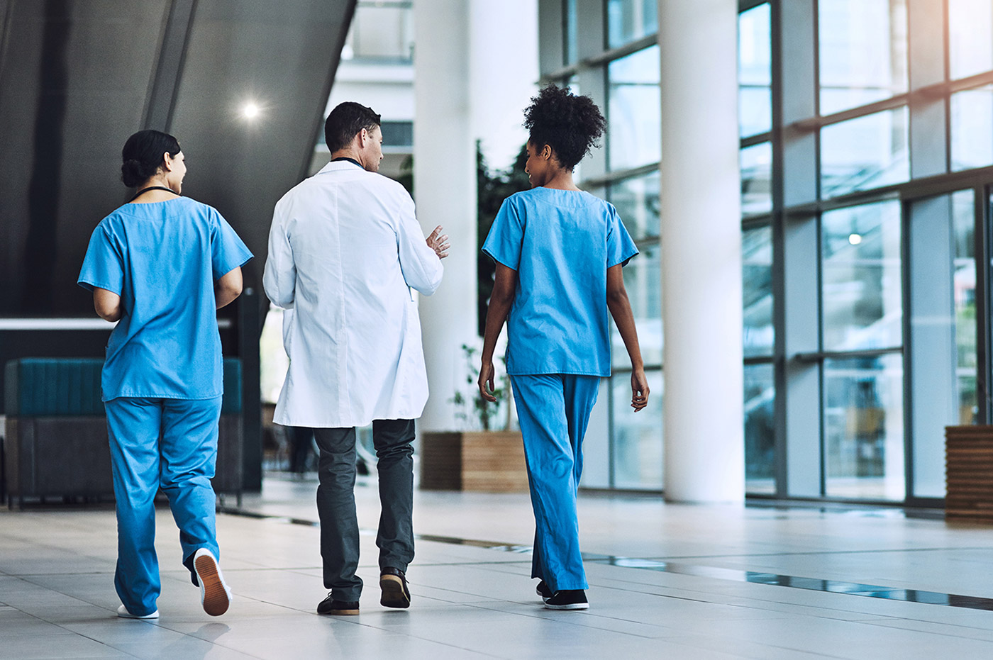 Three healthcare workers walking together.