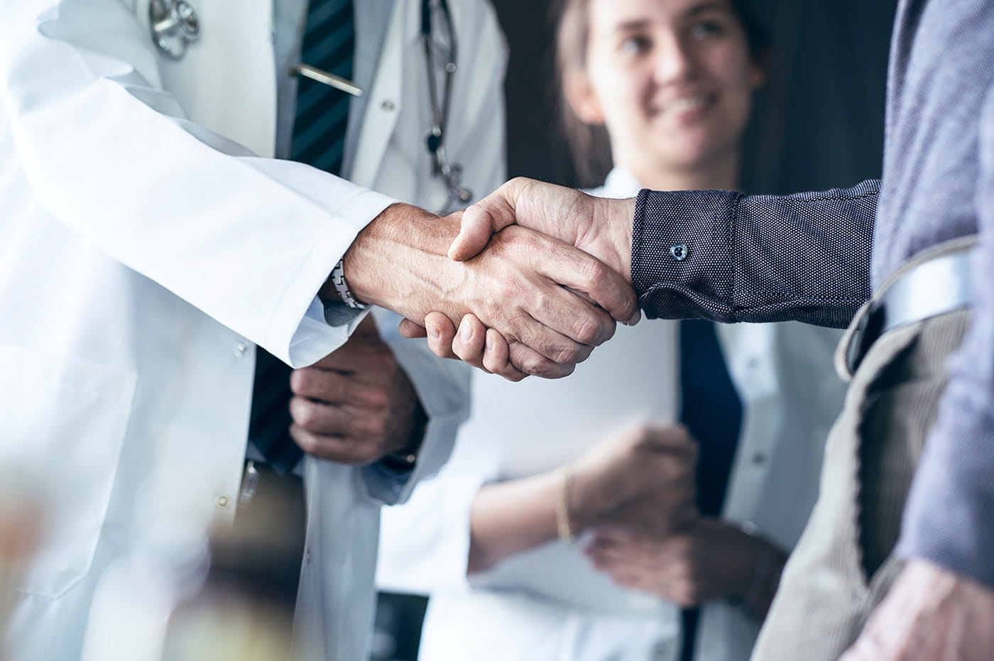 A doctor and a man shaking hands.