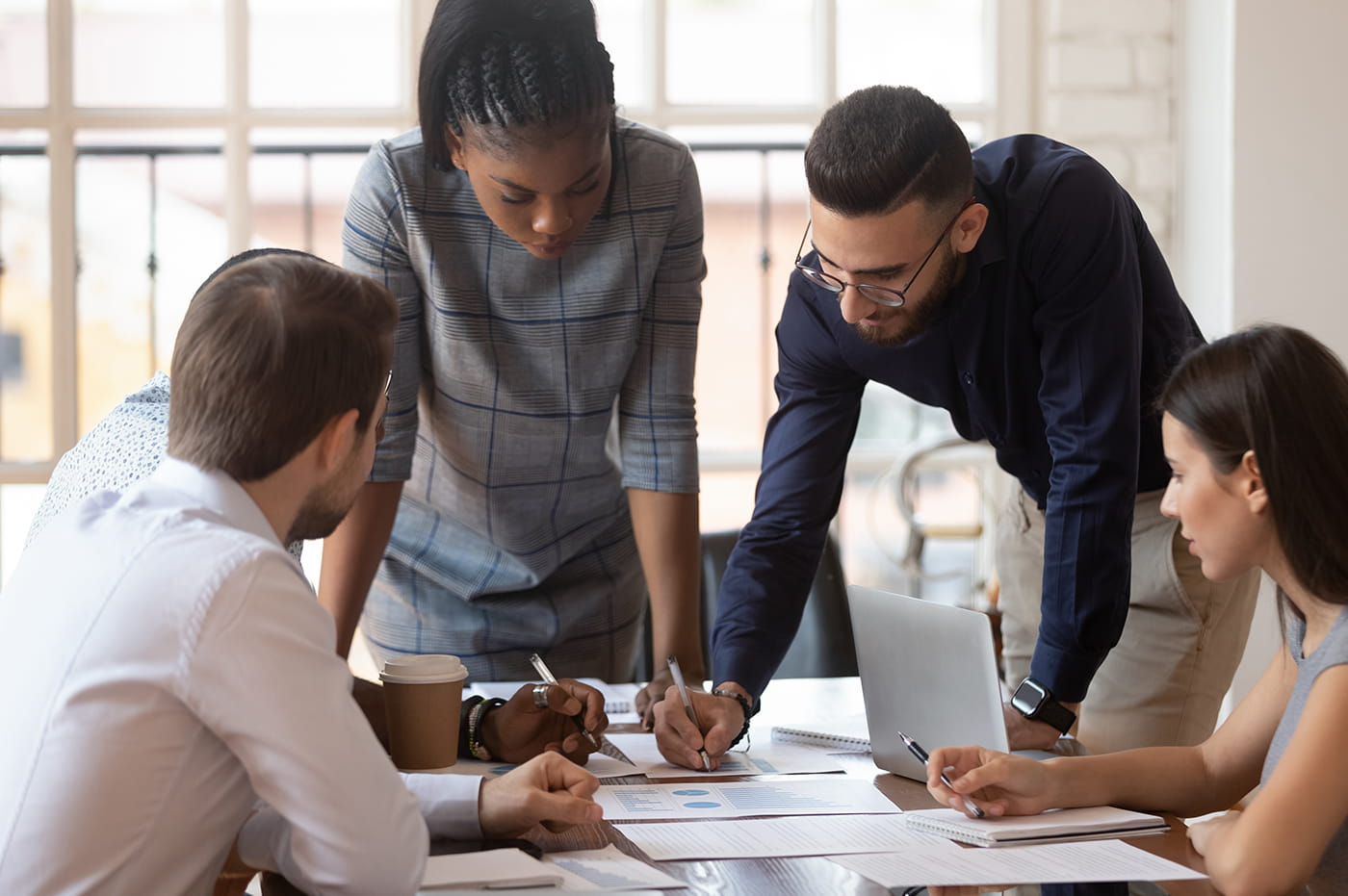 Four young professionals working together at a table.