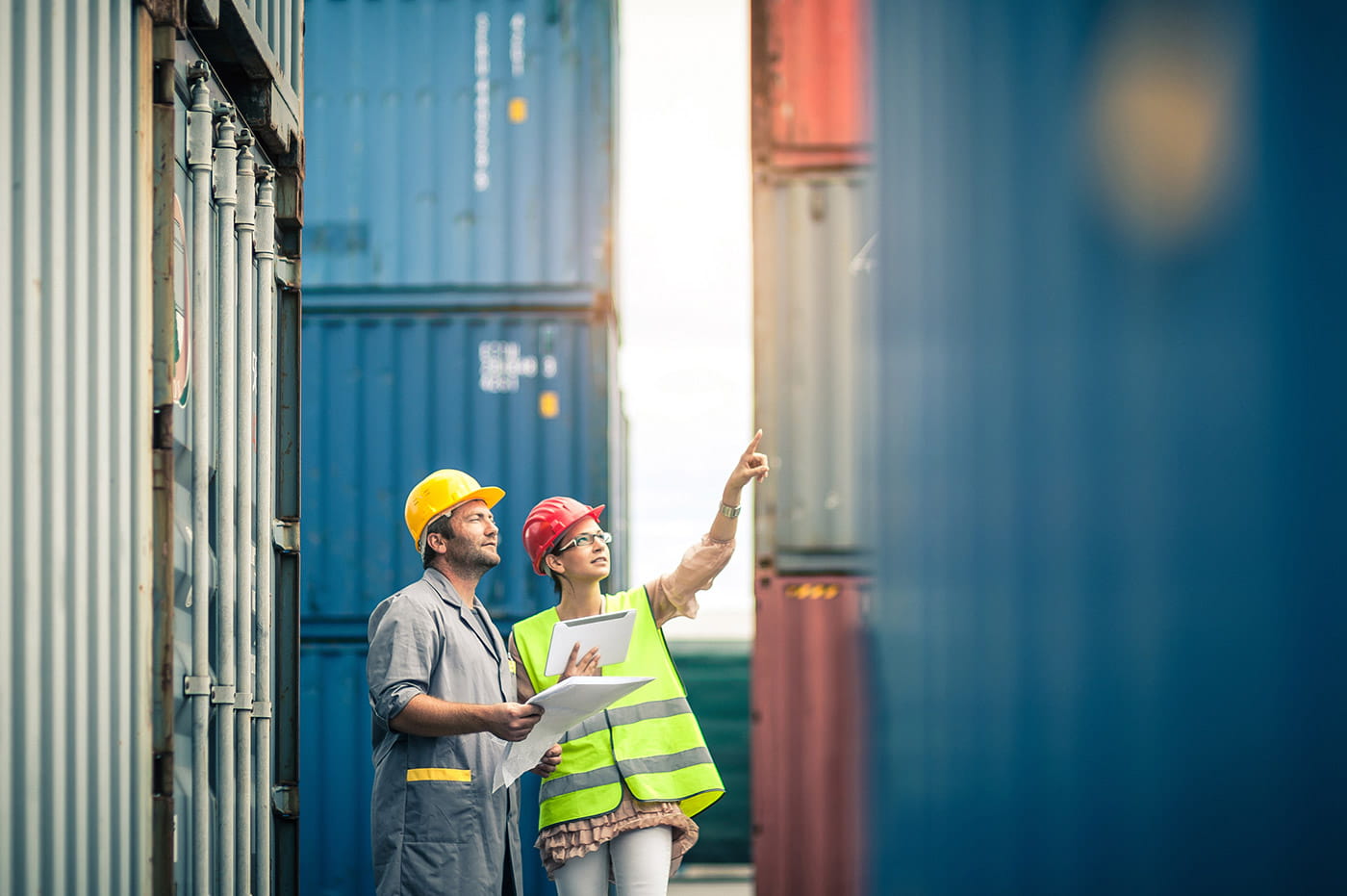 Two people in hard hats working in a shipping yard.