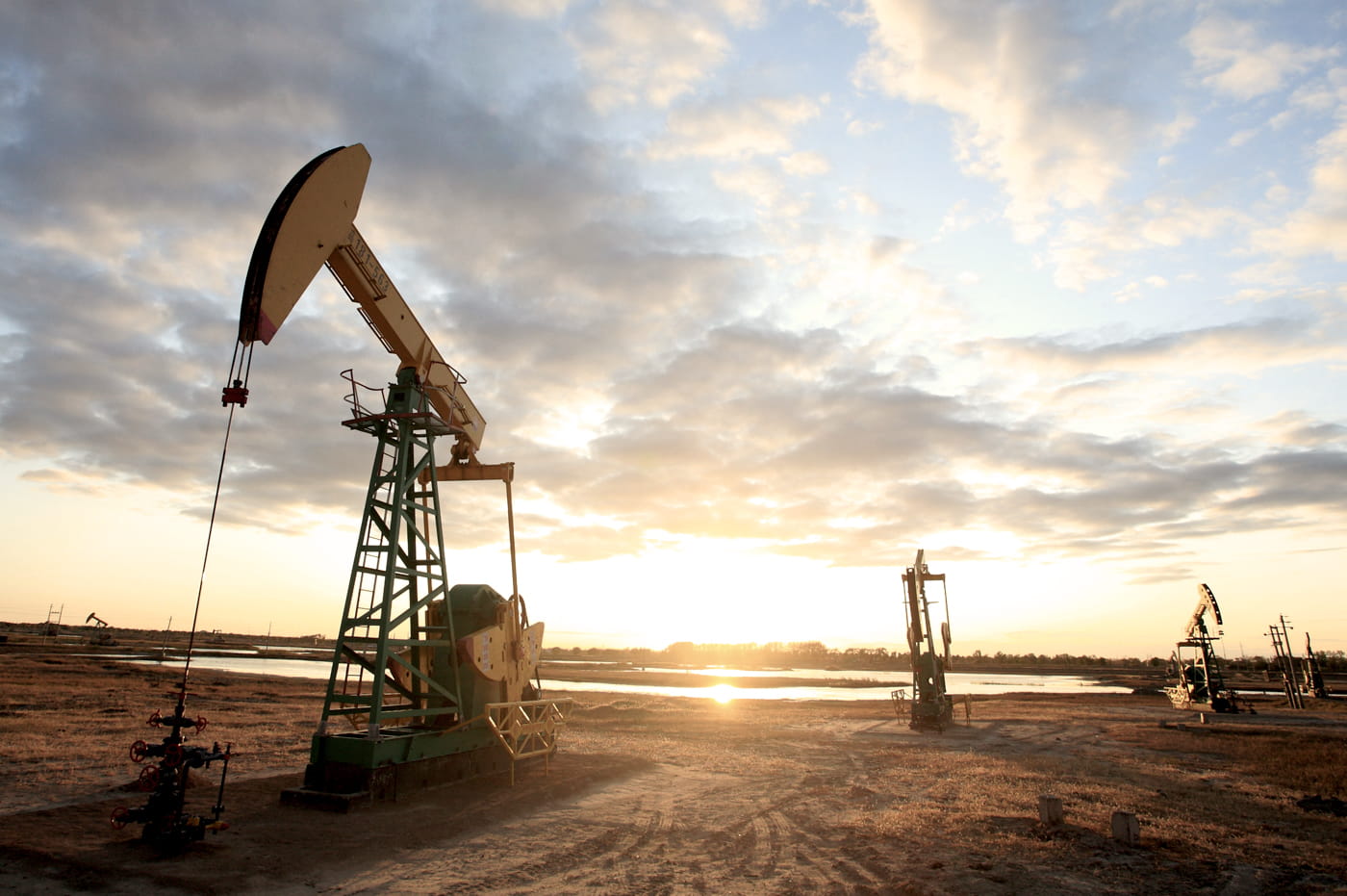 A field of oil rigs at sunset.